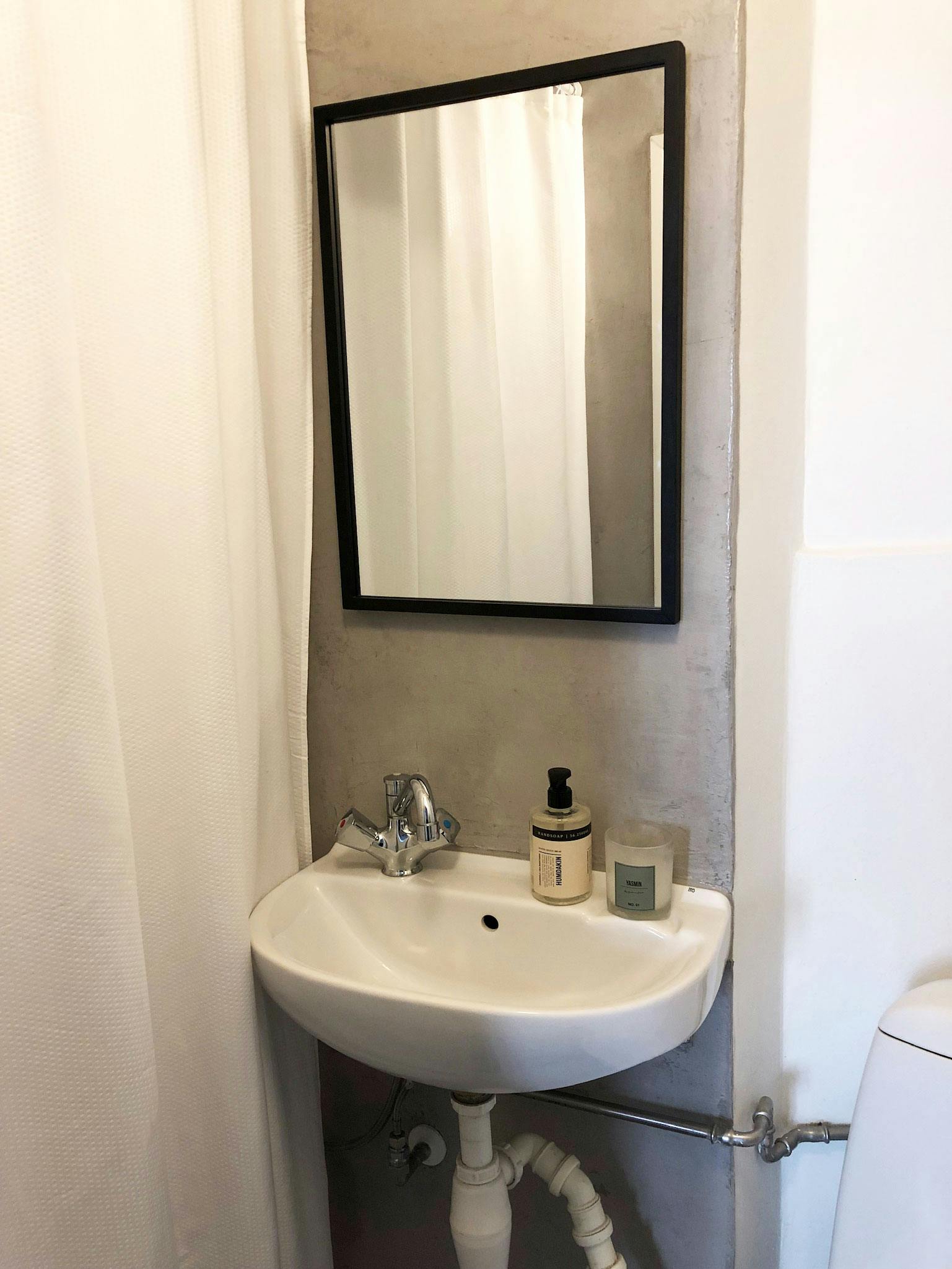 Håndvask og spel i badeværelse med betonlook