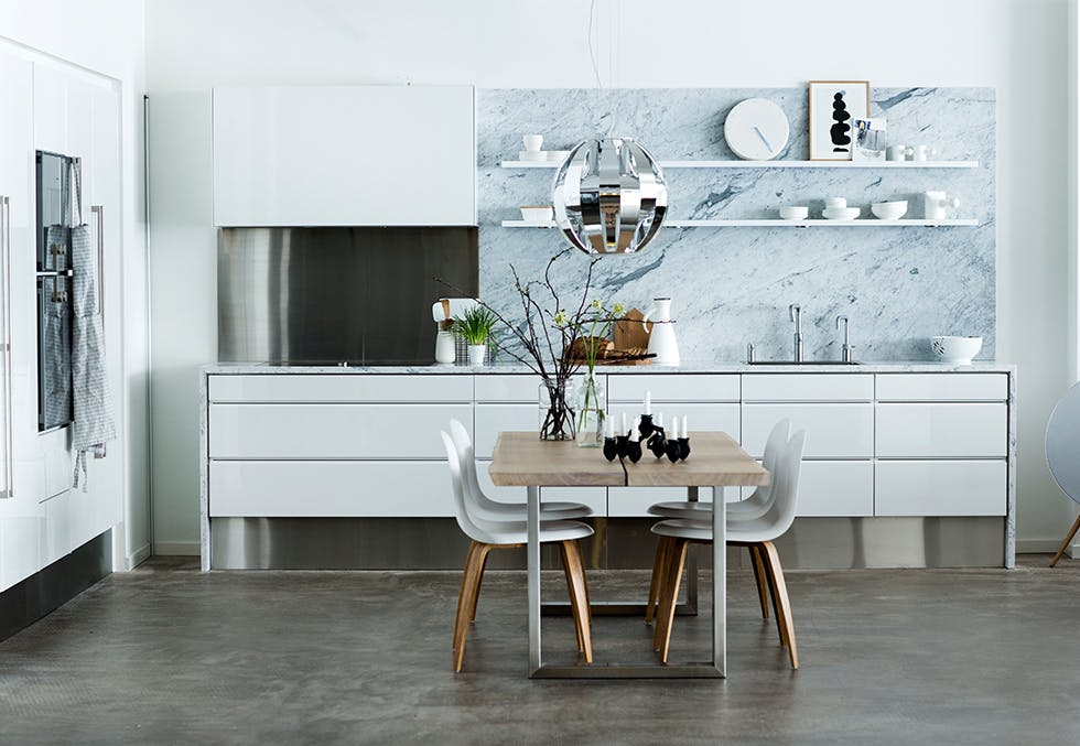 Kjøkken med benkeplate og vegg i hvit marmor