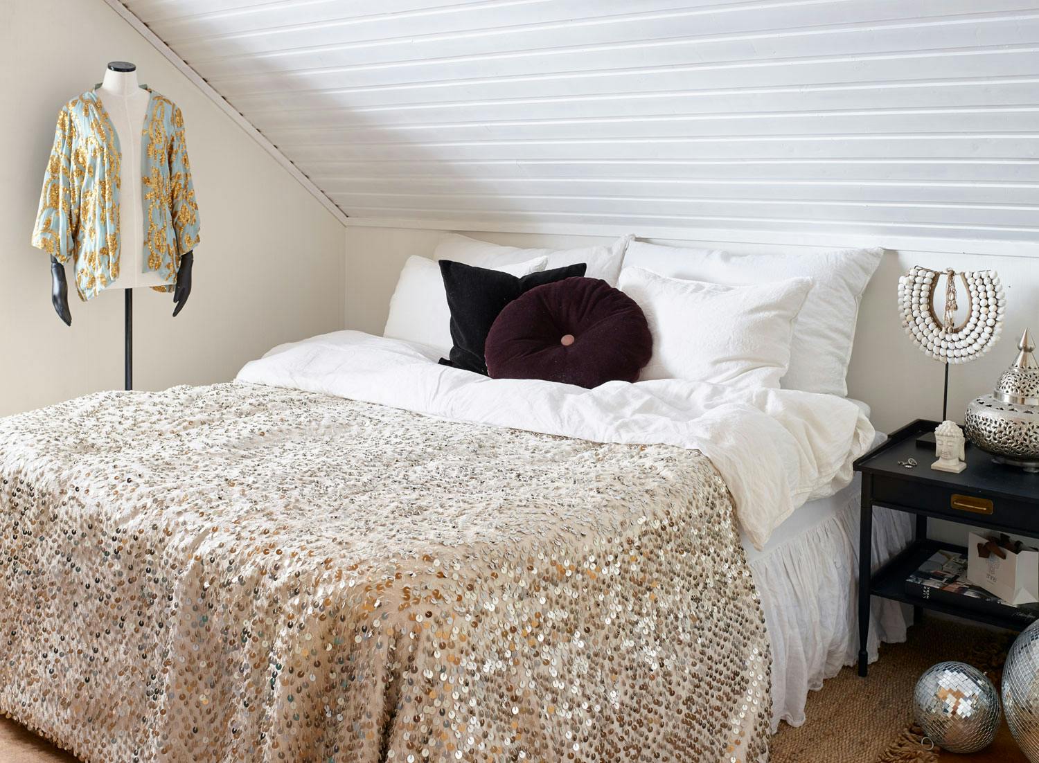 Sengetøyet i lin er fra Høie, putene er fra Christina Lundsteen og Madam Stoltz, tribal-smykket er fra Vakre rom og diskokulen er fra Milla Boutique.