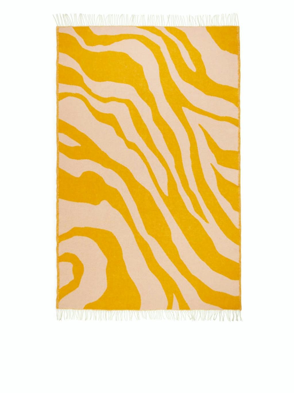 Gul og beige zebra stribet gulvtæppe fra Arket.