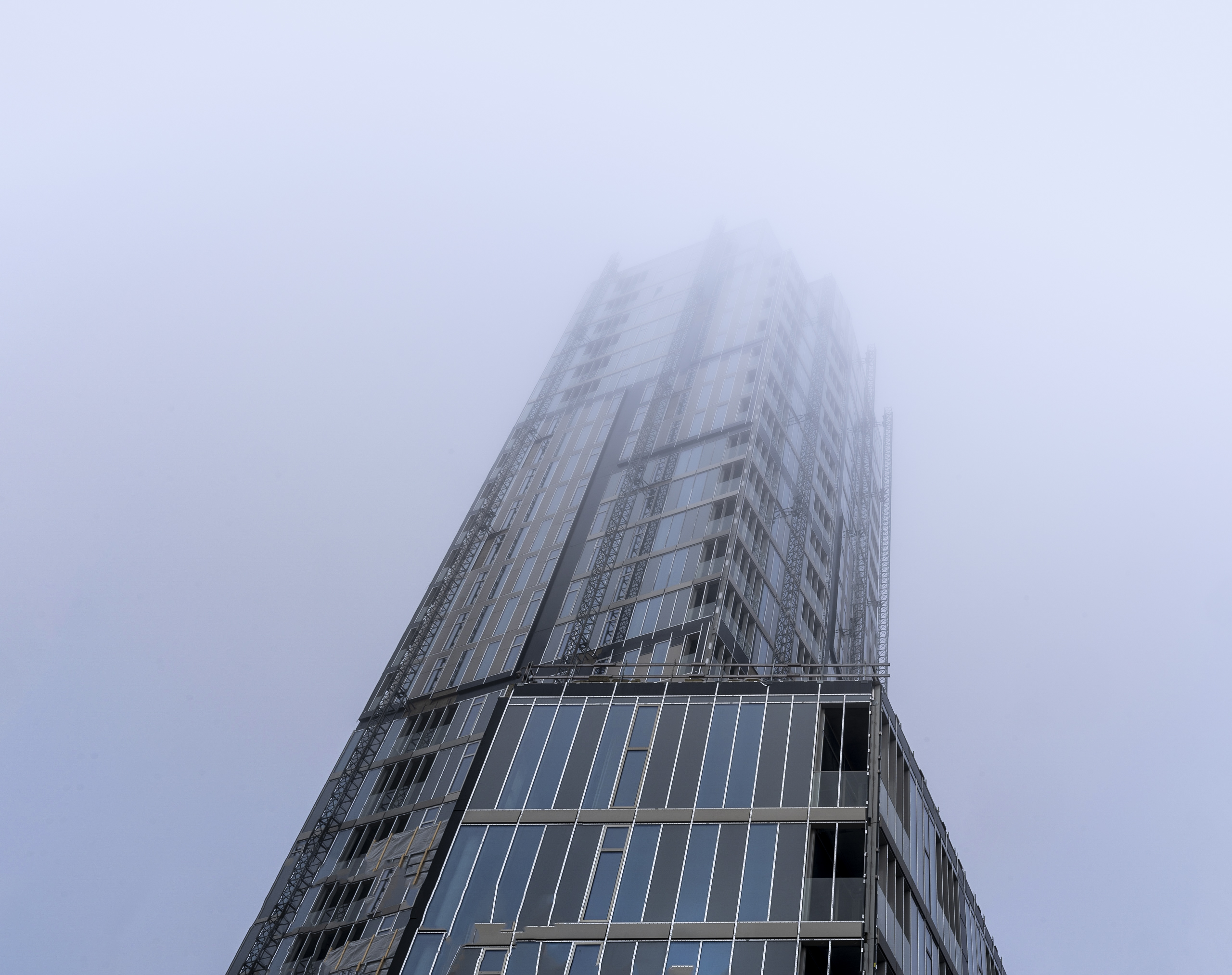 Byggnad under uppförande vintertid, med dimma och dis runt motivet