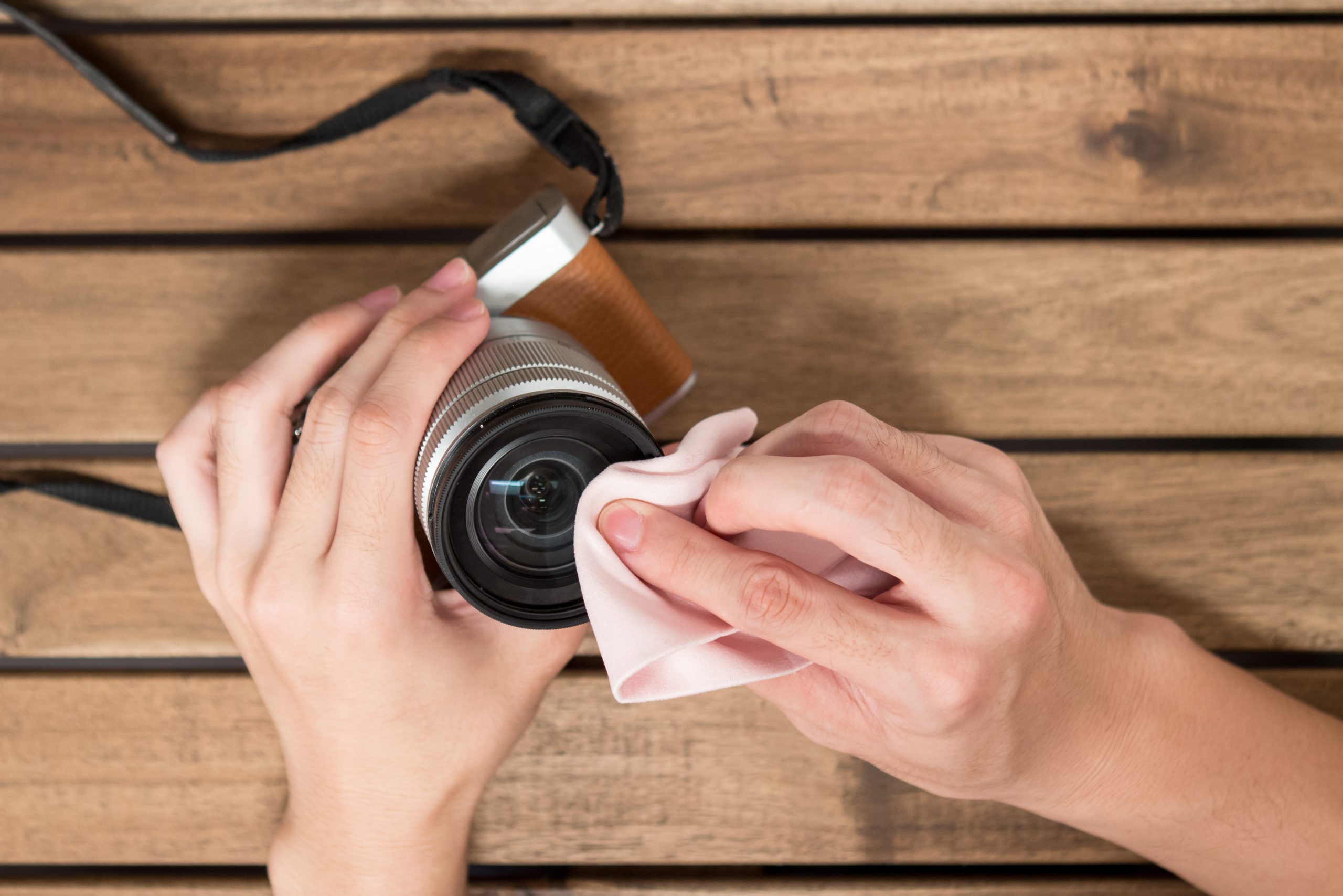 Mand pudser linsen på objektivet.