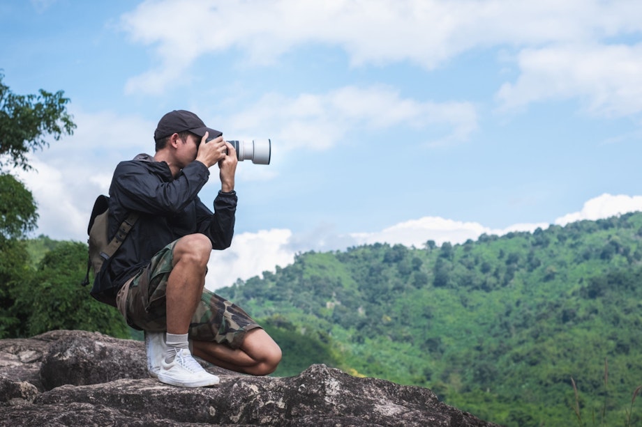 Fotograf på bergstopp. 