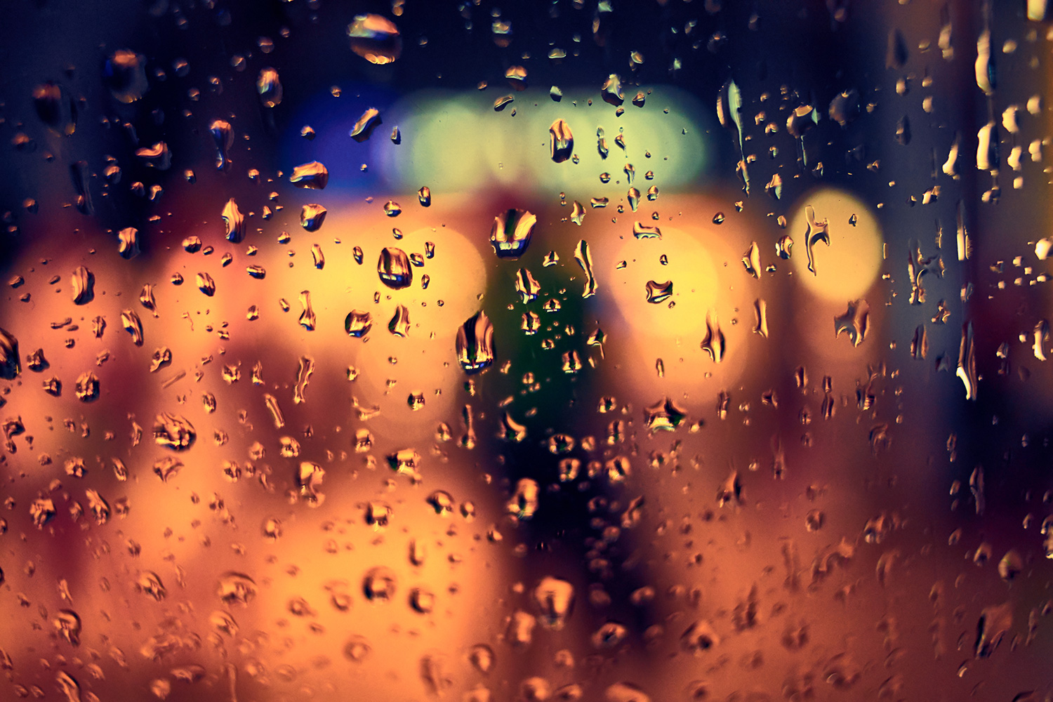 Sadepisaroita ikkunassa pimeällä.