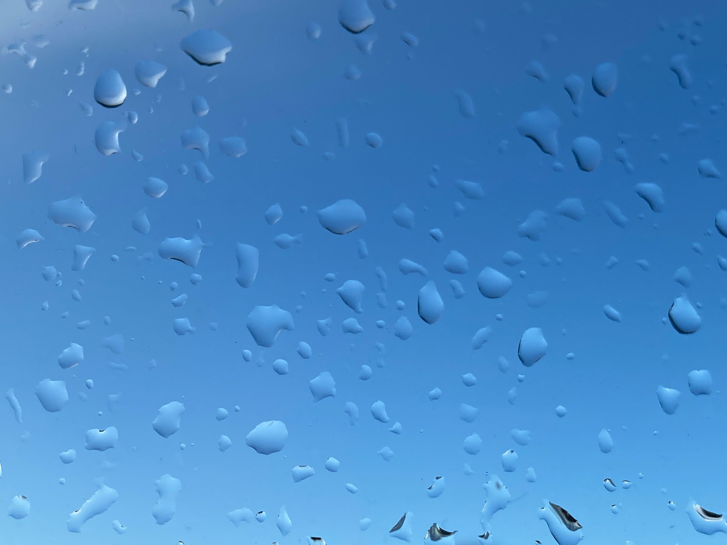 Dråber på rude med himlen som baggrund