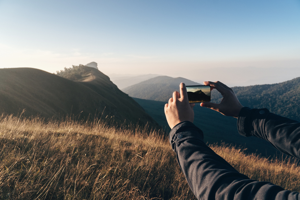 Mobilfotografering på en kulle i gyllene ljus