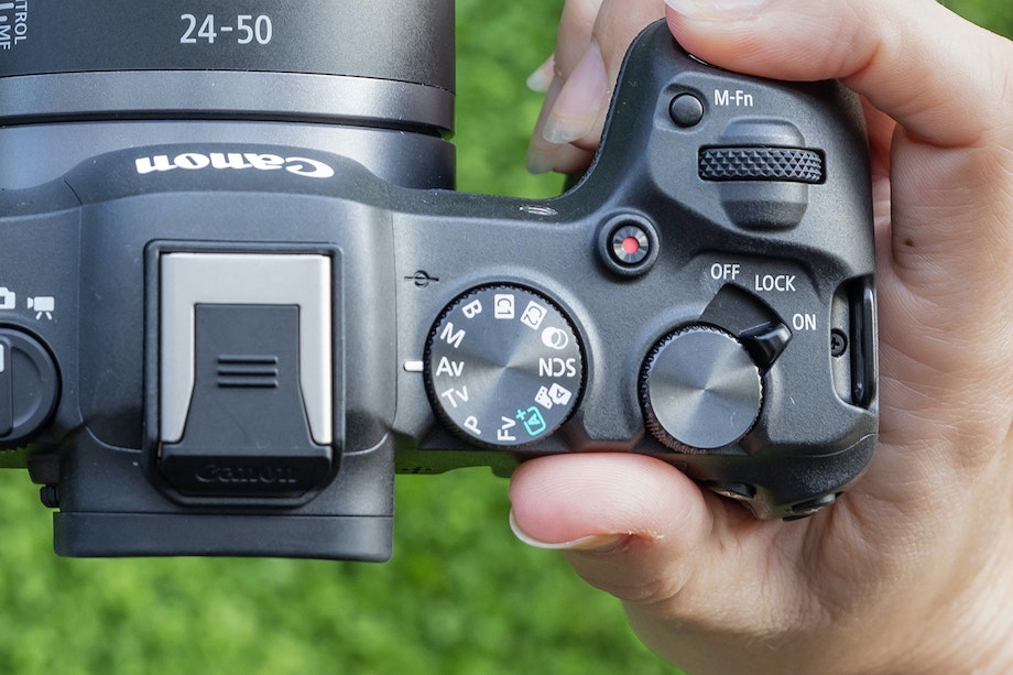 Hand håller en systemkamera