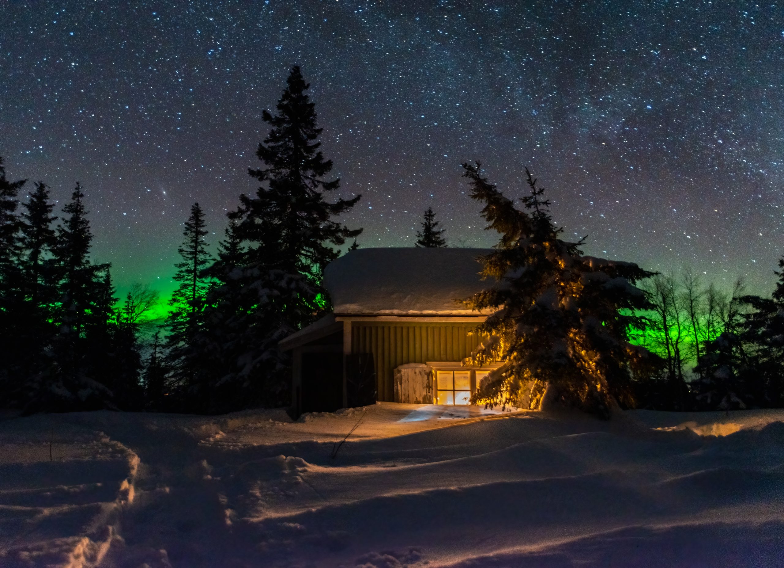 Hytte badet i sne og nordlys