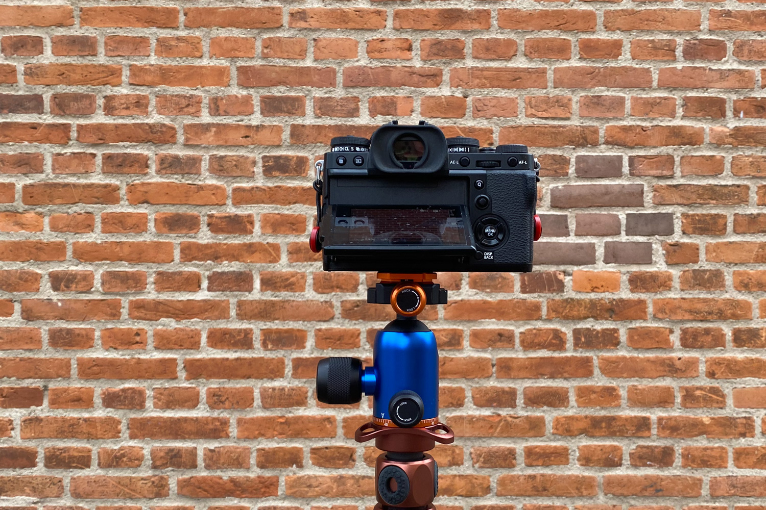 Kamera på stativ foran mustrensvæg