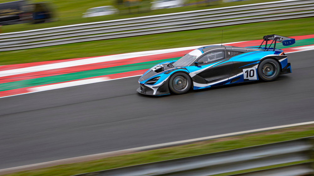 Racerbil på bane fotografert med langt teleobjektiv på lang lukkertid