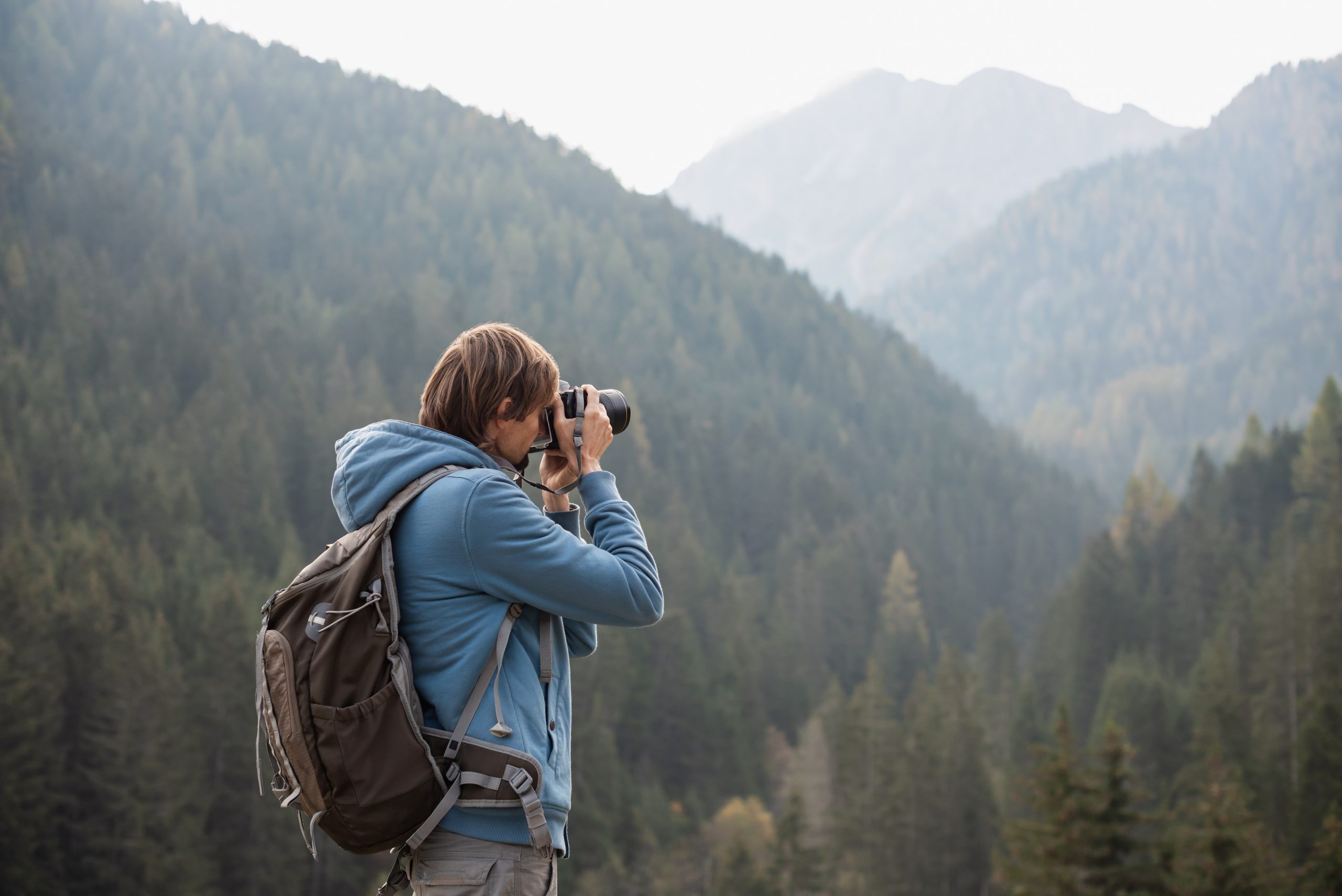 Man fotograferar i skogen.
