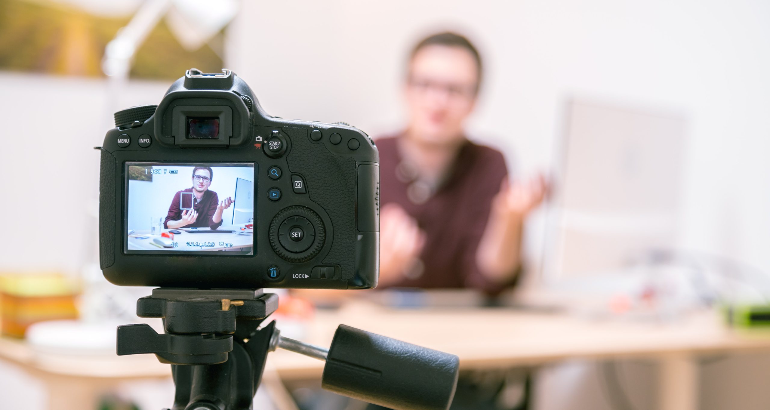 Mies istuu kameran edessä toimistossa