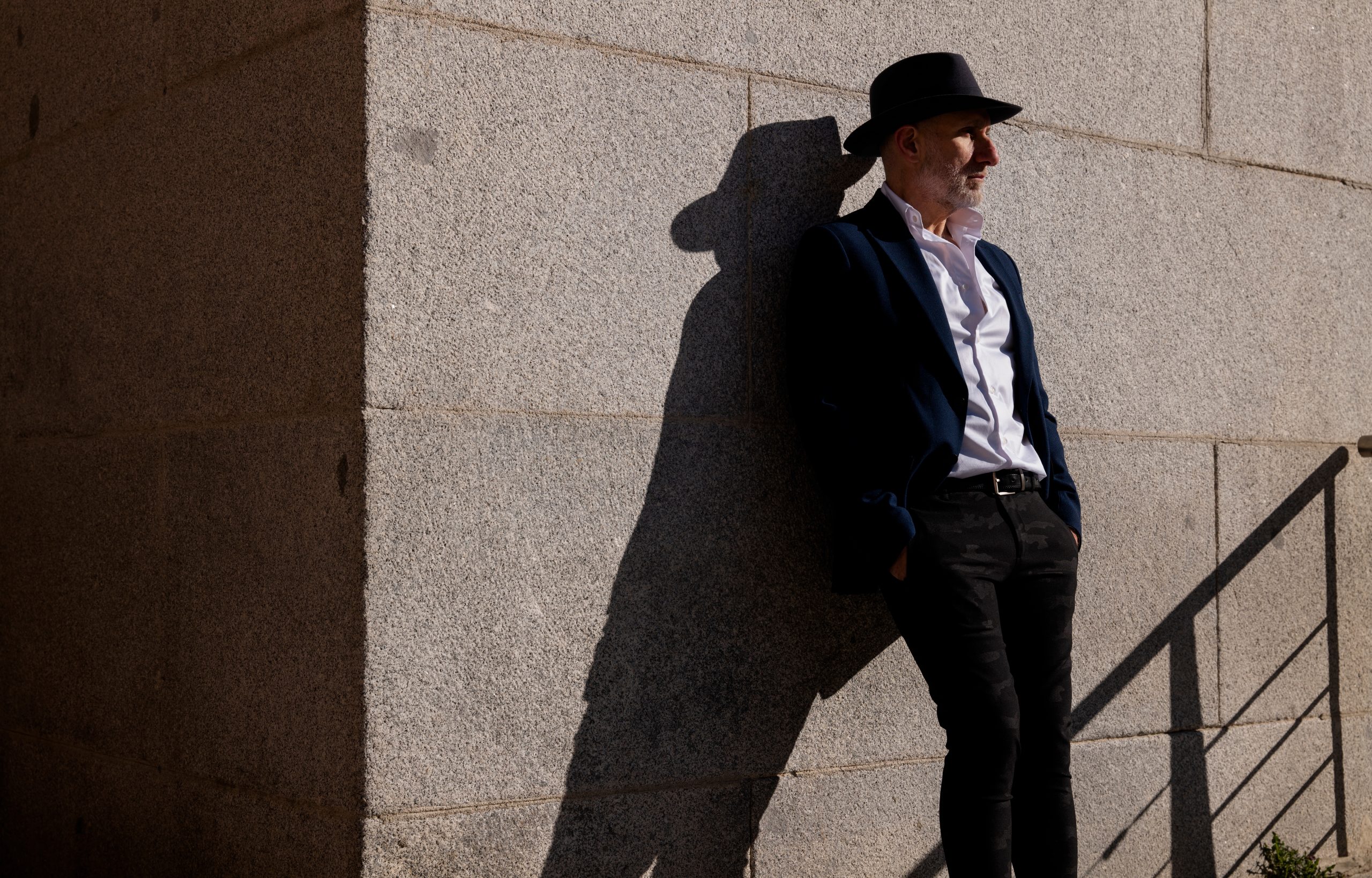 Mies nojaa seinää vasten