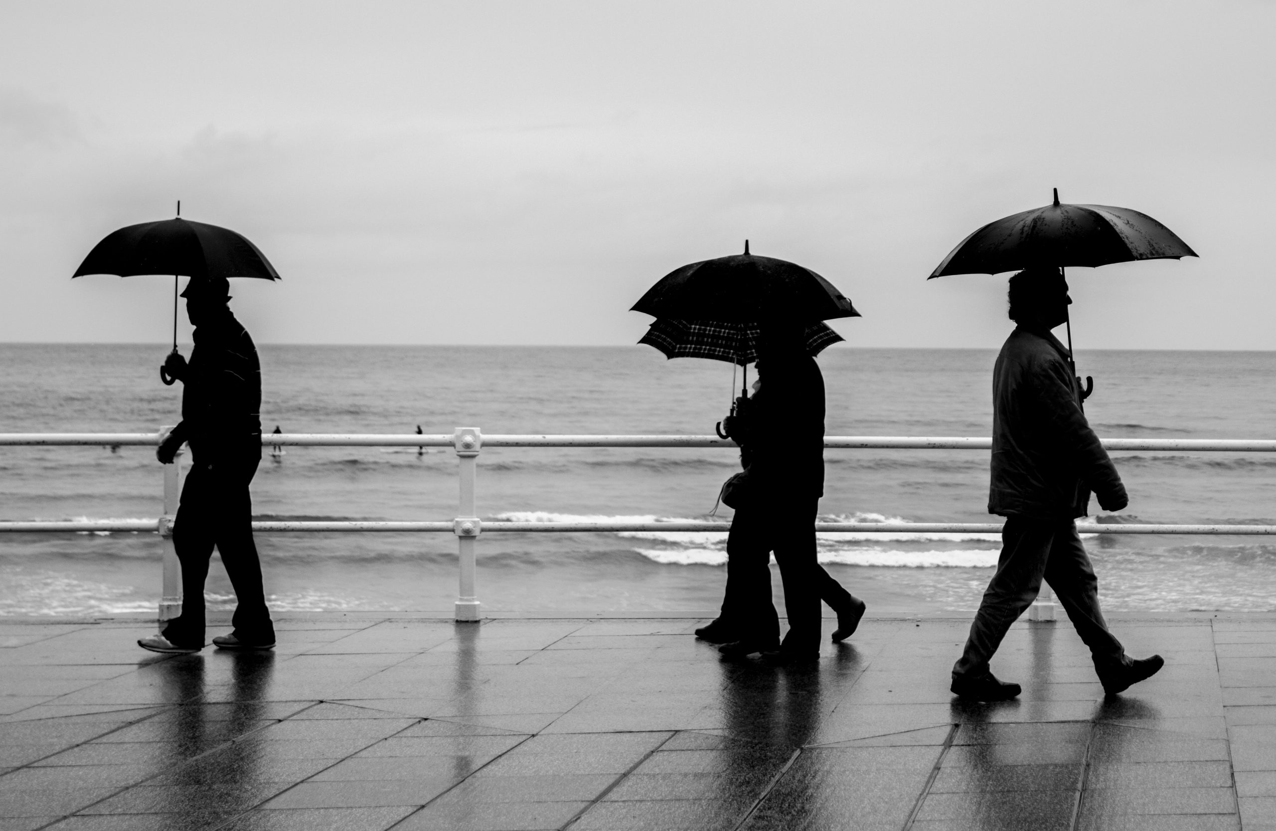 ihmisiä sateenvarjo merenranta