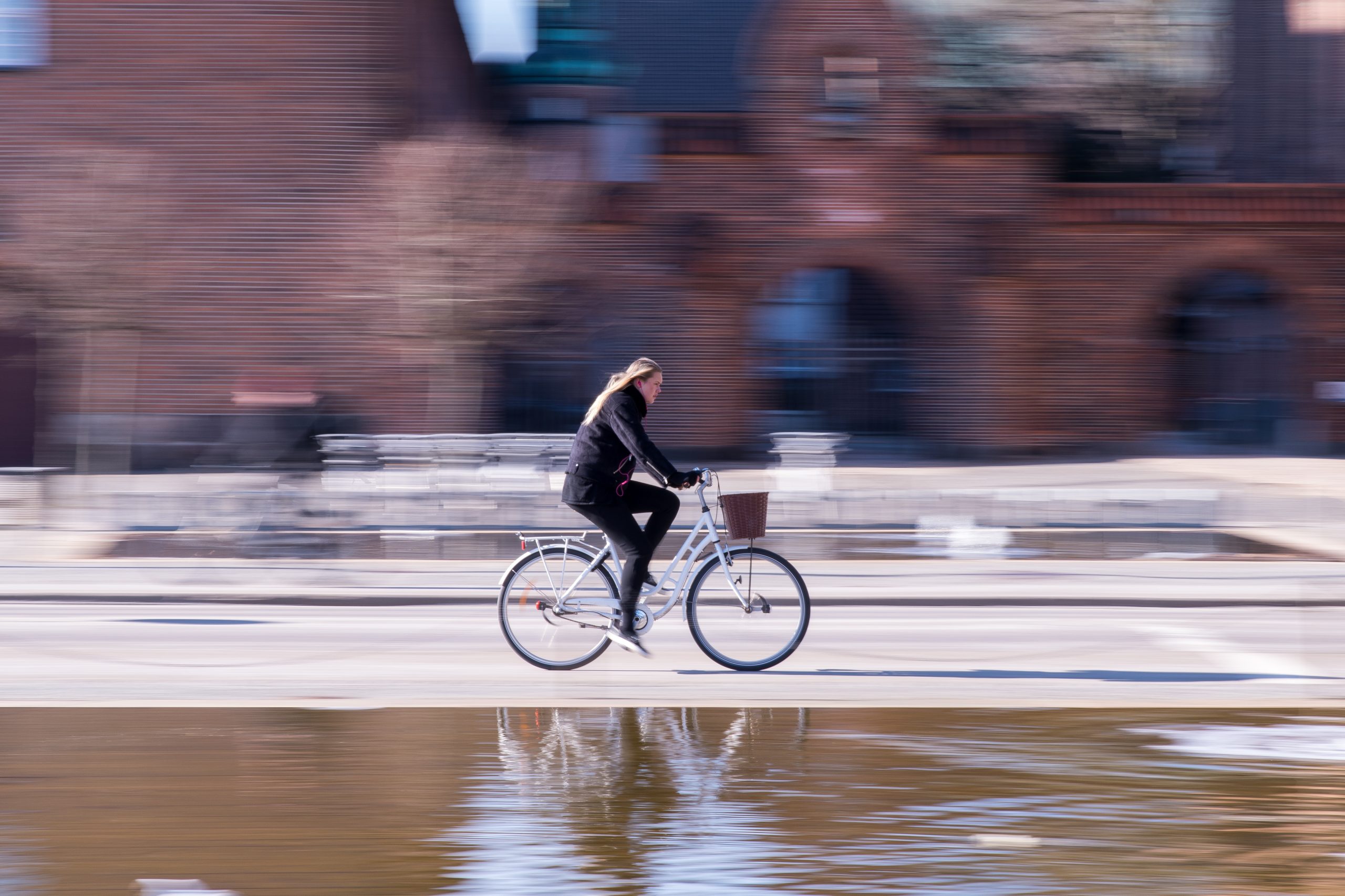 Cyklist kör förbi framför fontän