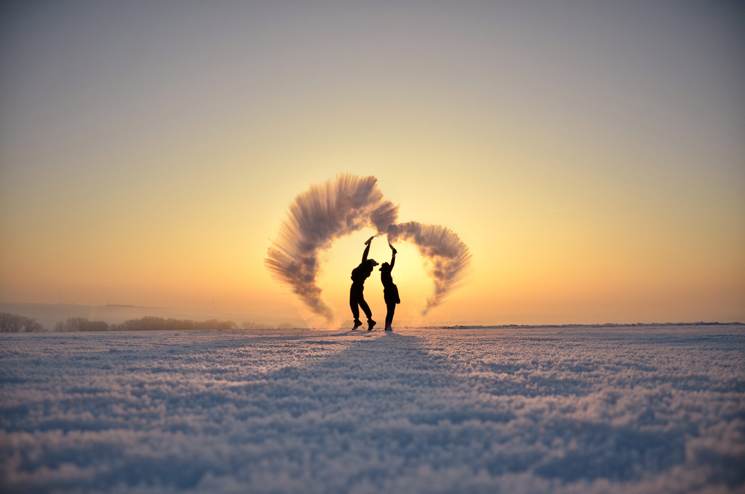 Silhuetter av personer som kaster snø