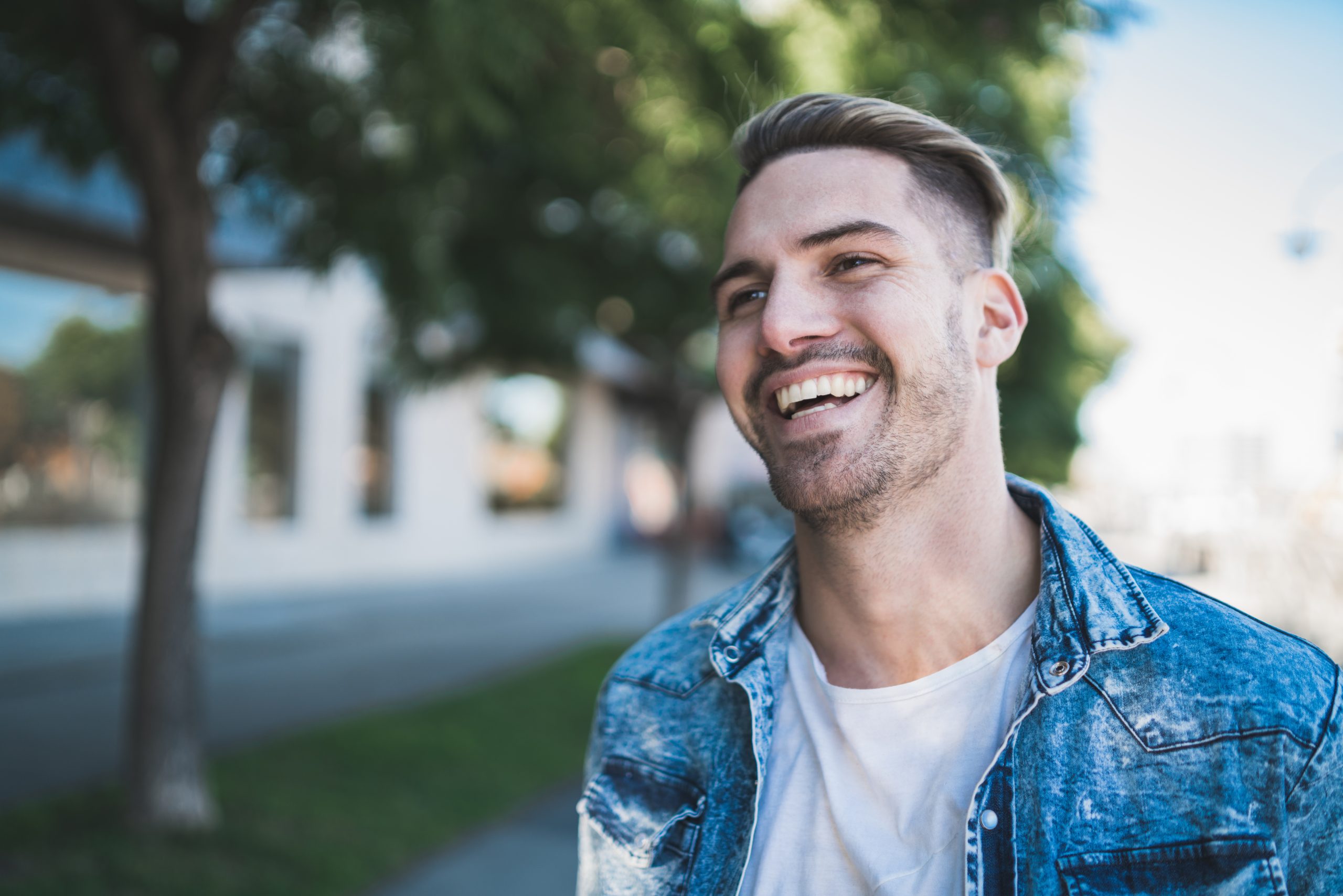 Nuori mies hymyilee kadulla 