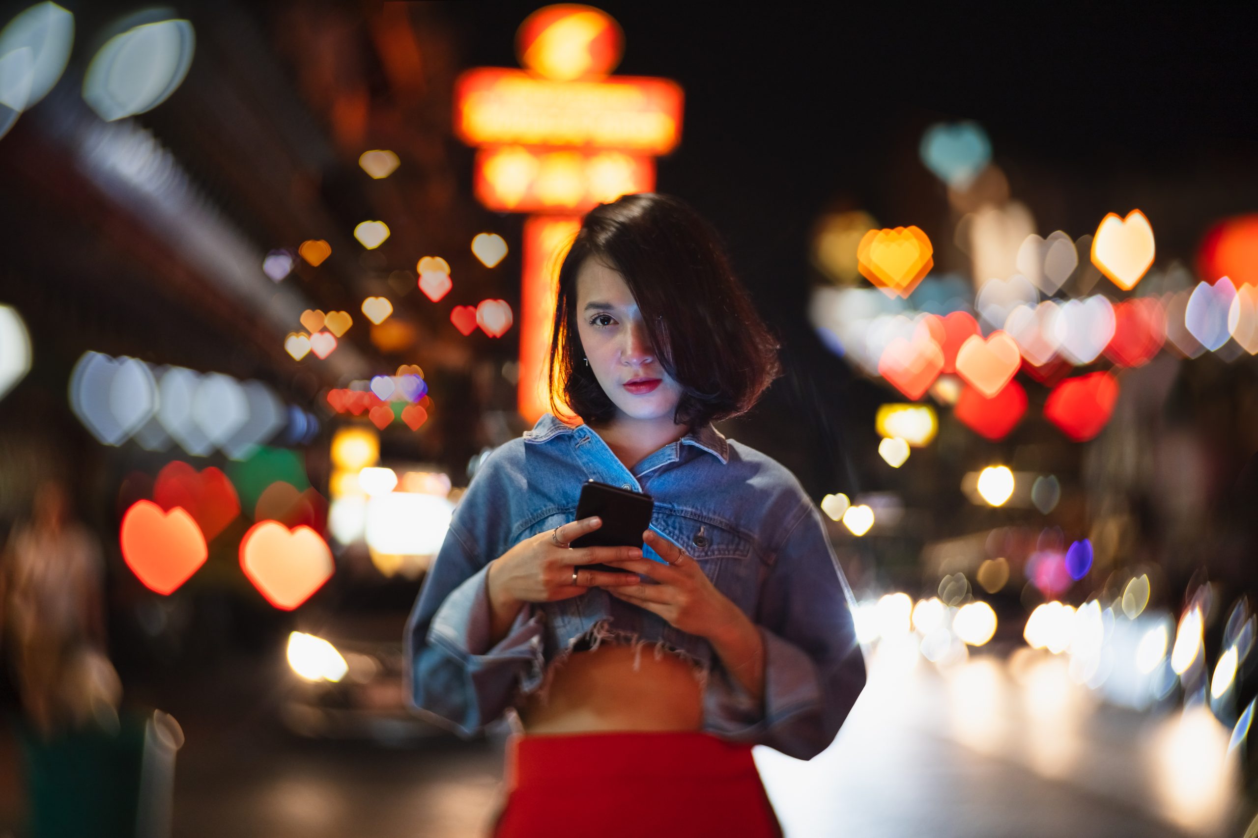 Porträtt av kvinna med hjärtformad bokeh i bakgrunden.