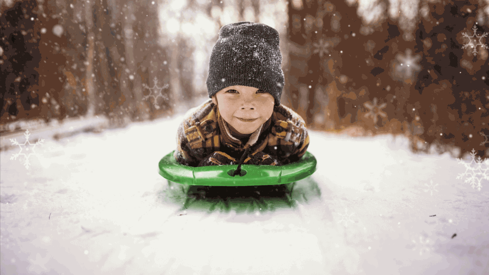Gutt kjører kjelke i snøen