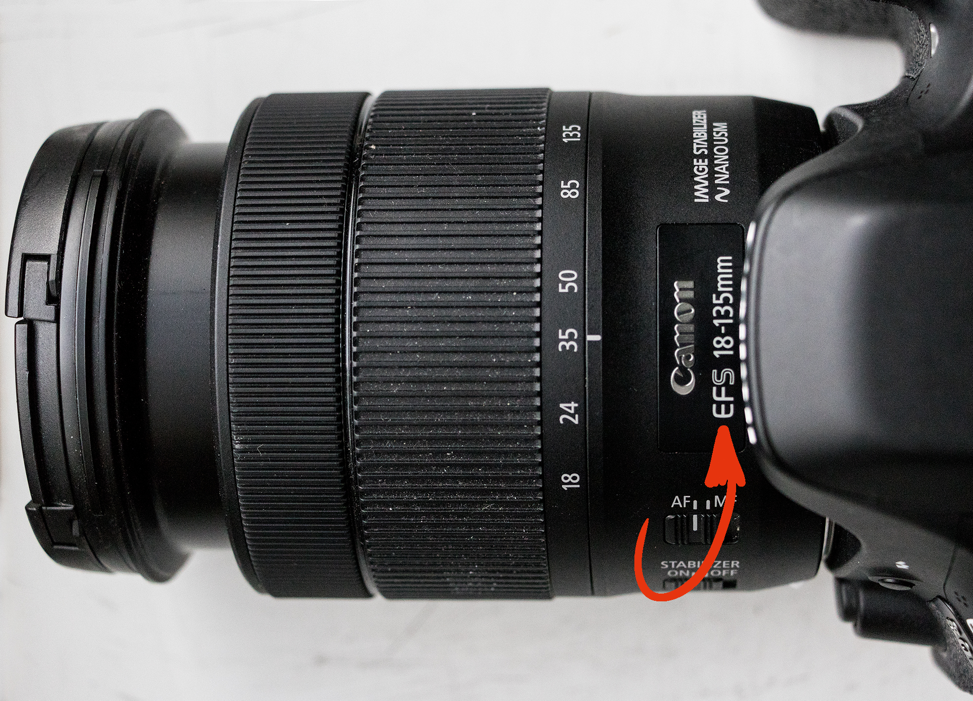 Canon 18–135 mm objektiv med pil ved fatningen