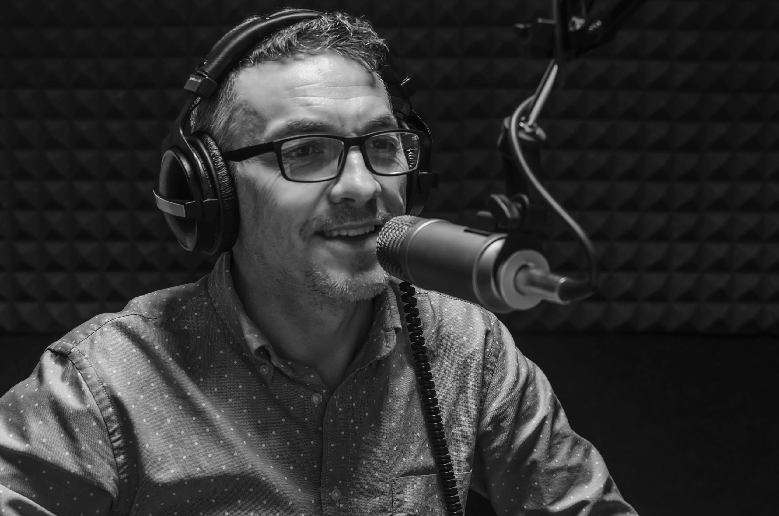 Mies puhuu mikrofoniin.