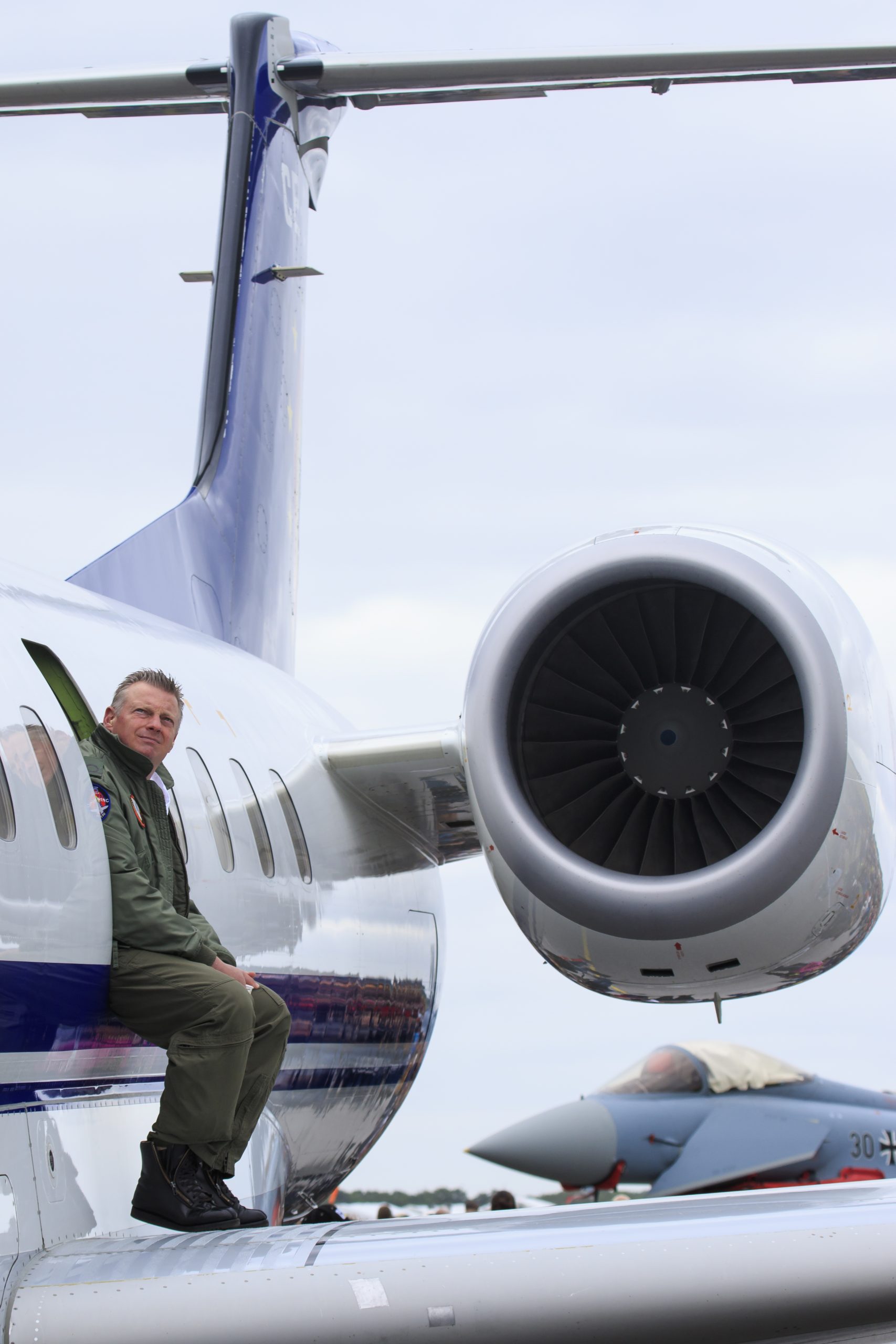 Pilot sitter på flygplan på marken vid flyguppvisning