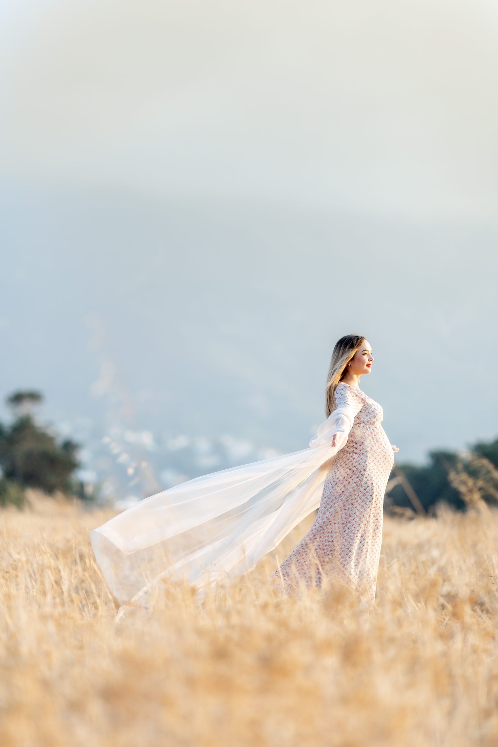 nuori nainen raskaana mekko laahus niitty