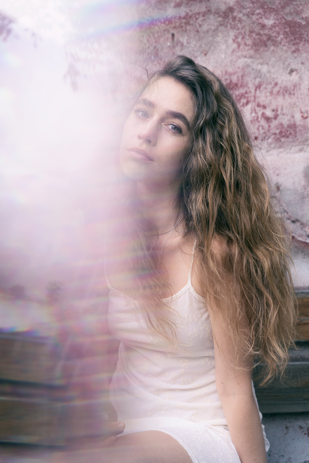 Porträtt av ung kvinna sittande på en bänk med prisma framför kameran