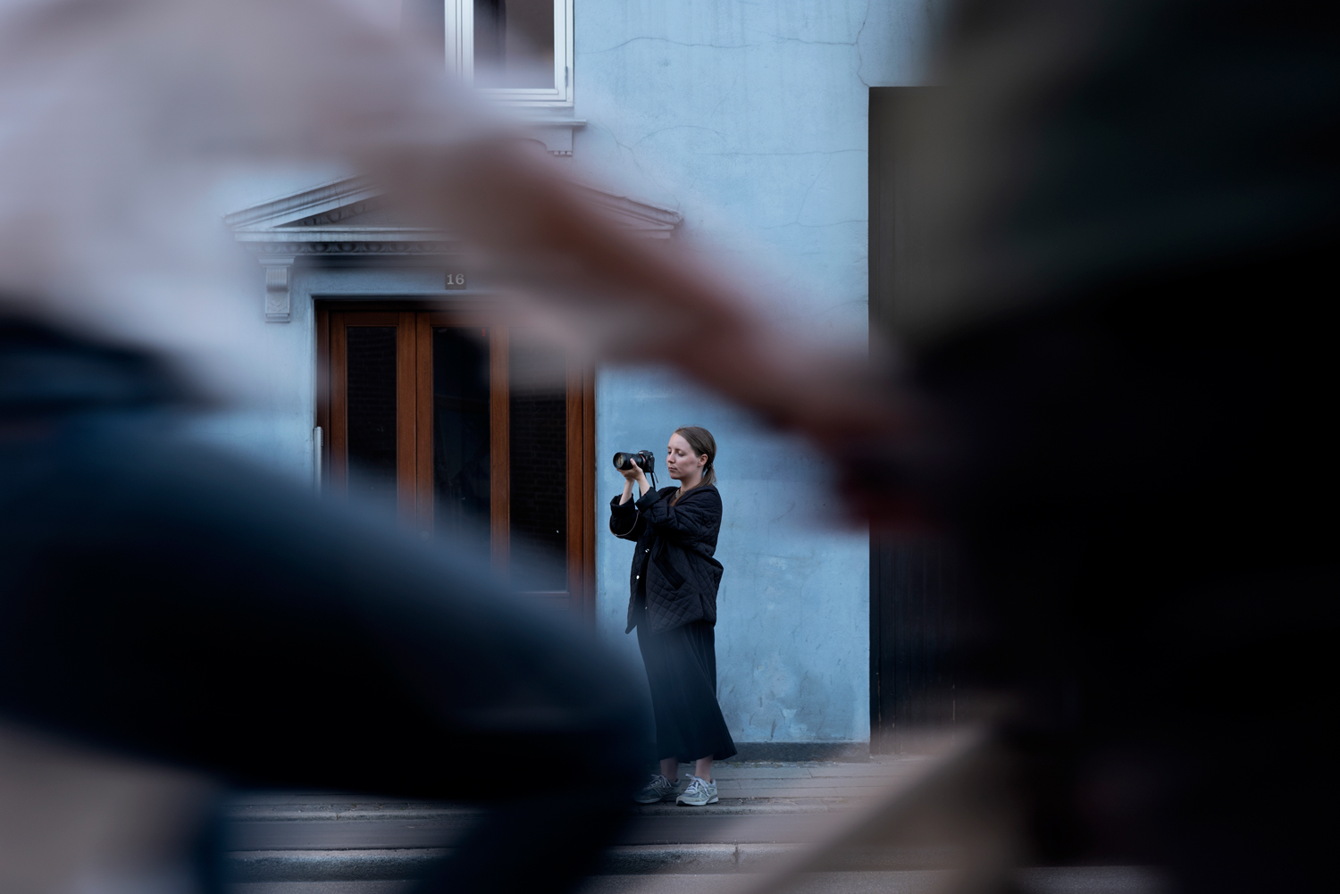 Fotograf med kamera omringet av mennesker