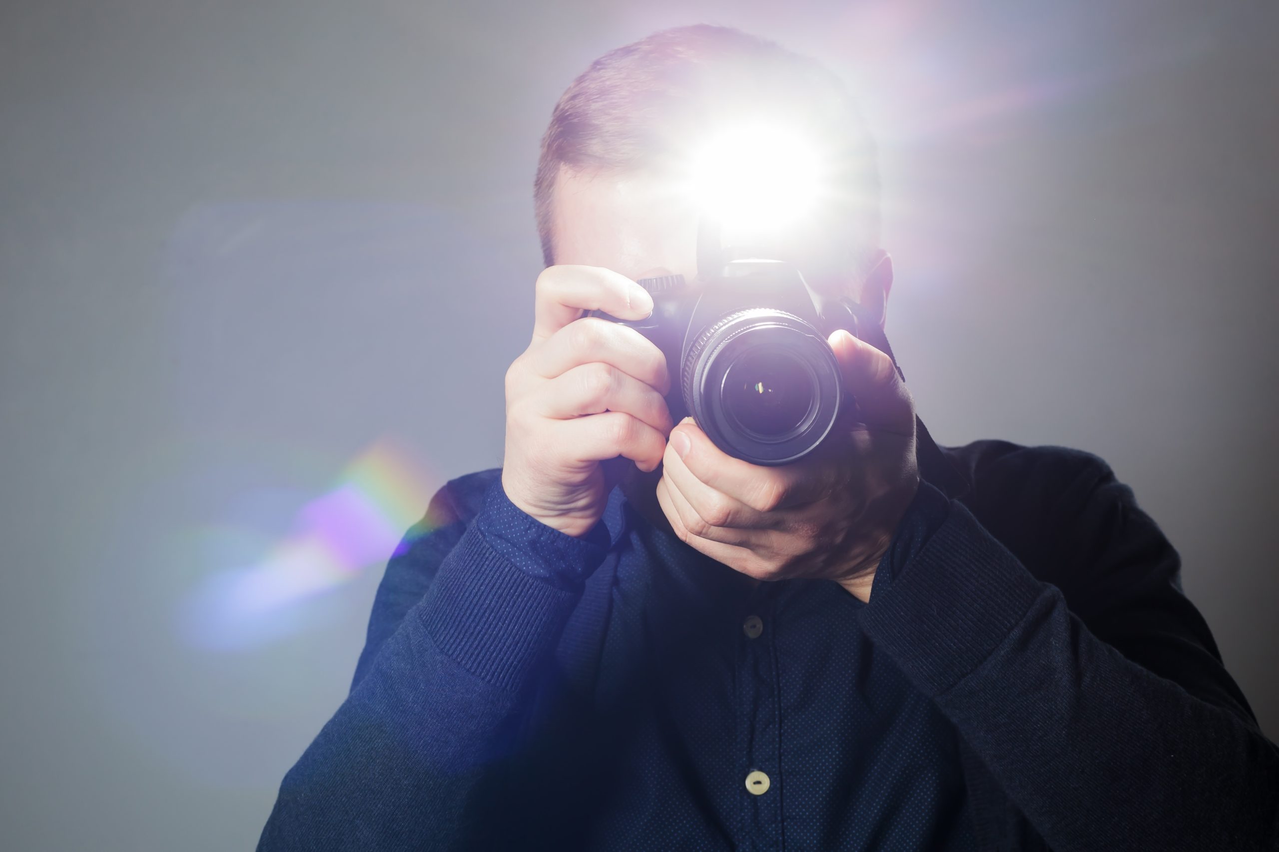 Man fotograferar med kamera och inbyggd blixt