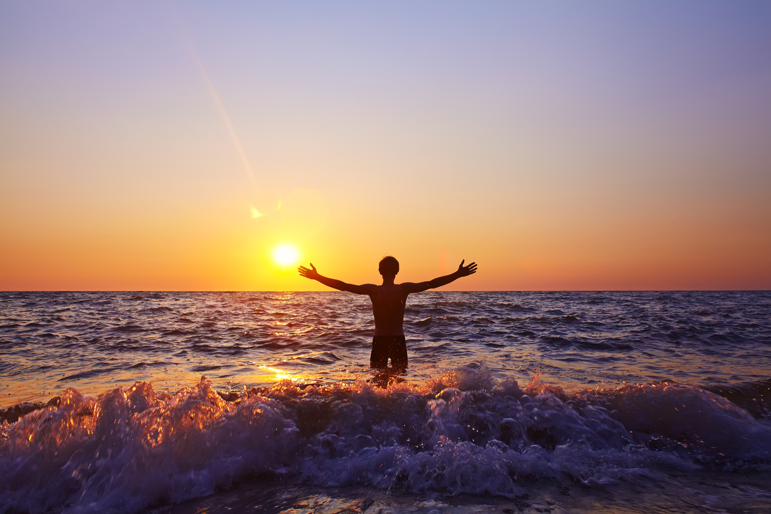 Mies vedessä auringonlaskussa