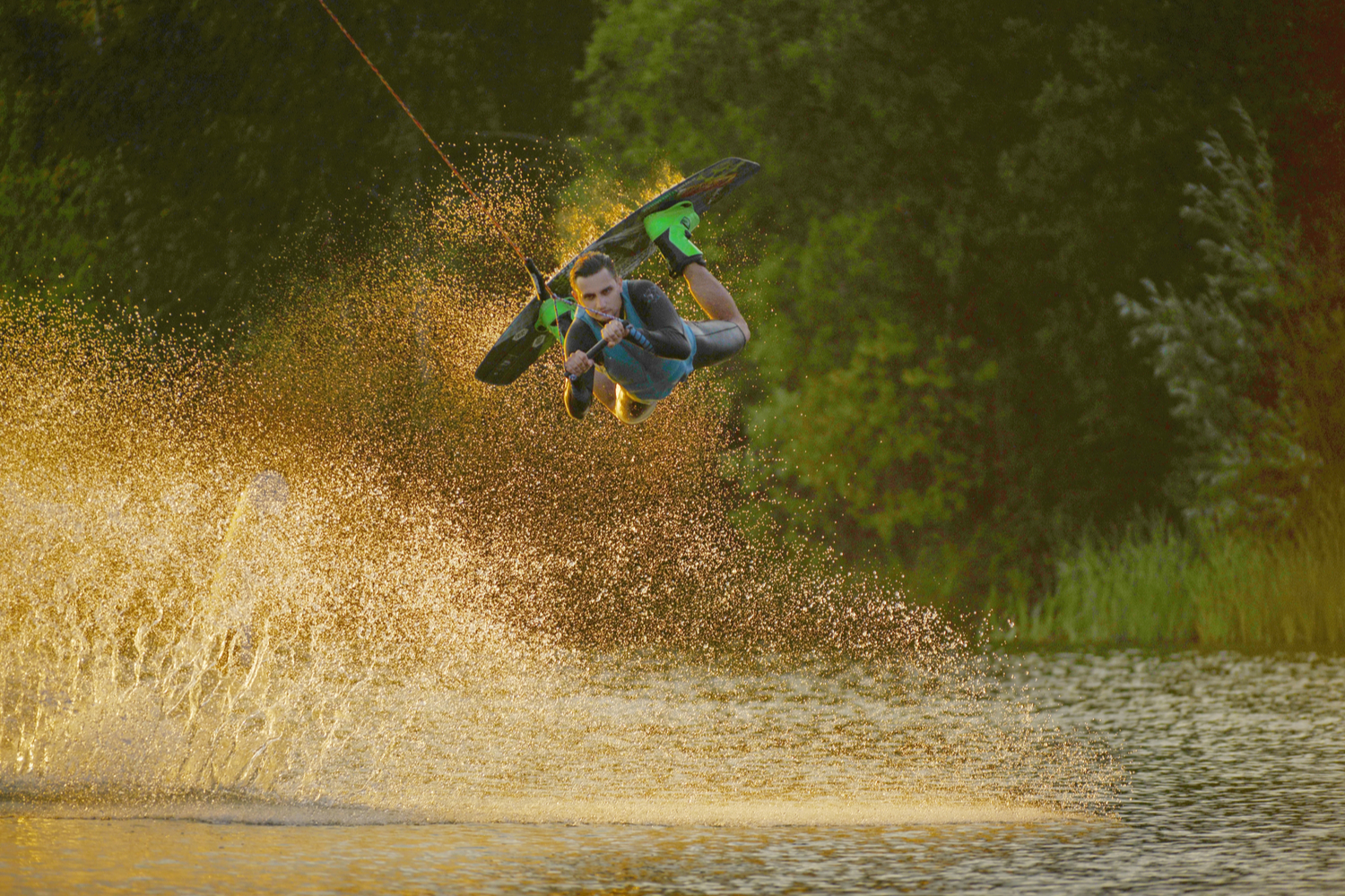 Wakeboarder laver tricks på rampe.