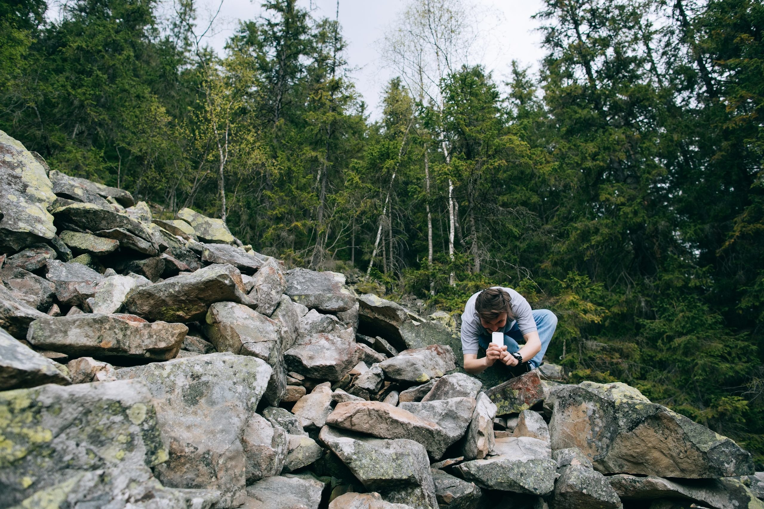 Man går ned på knä för att ta bild med mobiltelefon