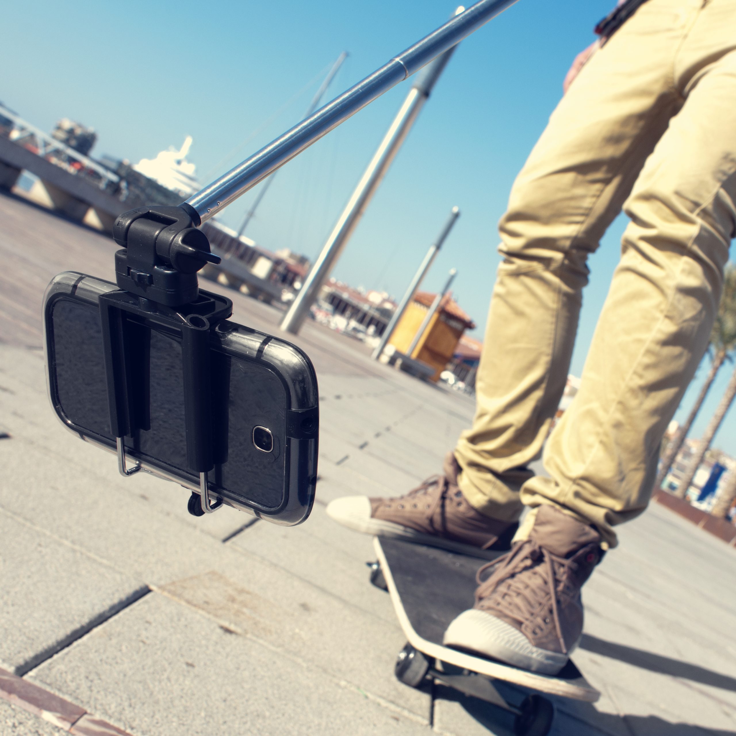 En skateboardåkare spelar in video med en selfiepinne