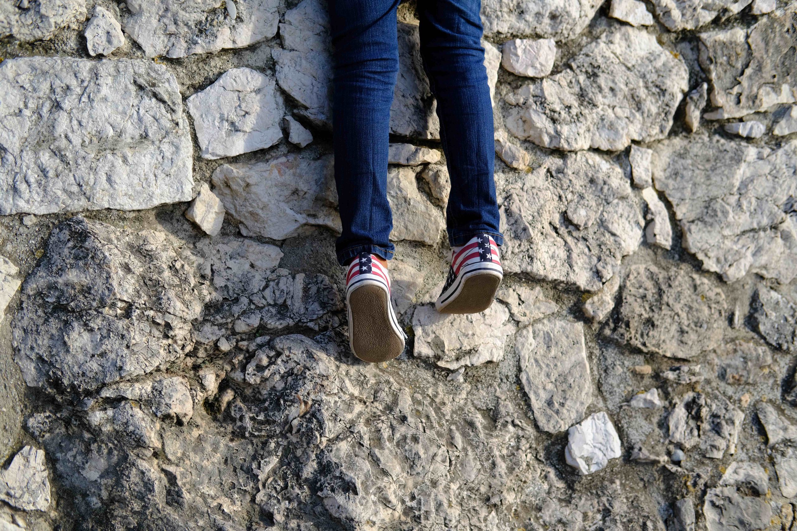 En pojke klättrar på en mur