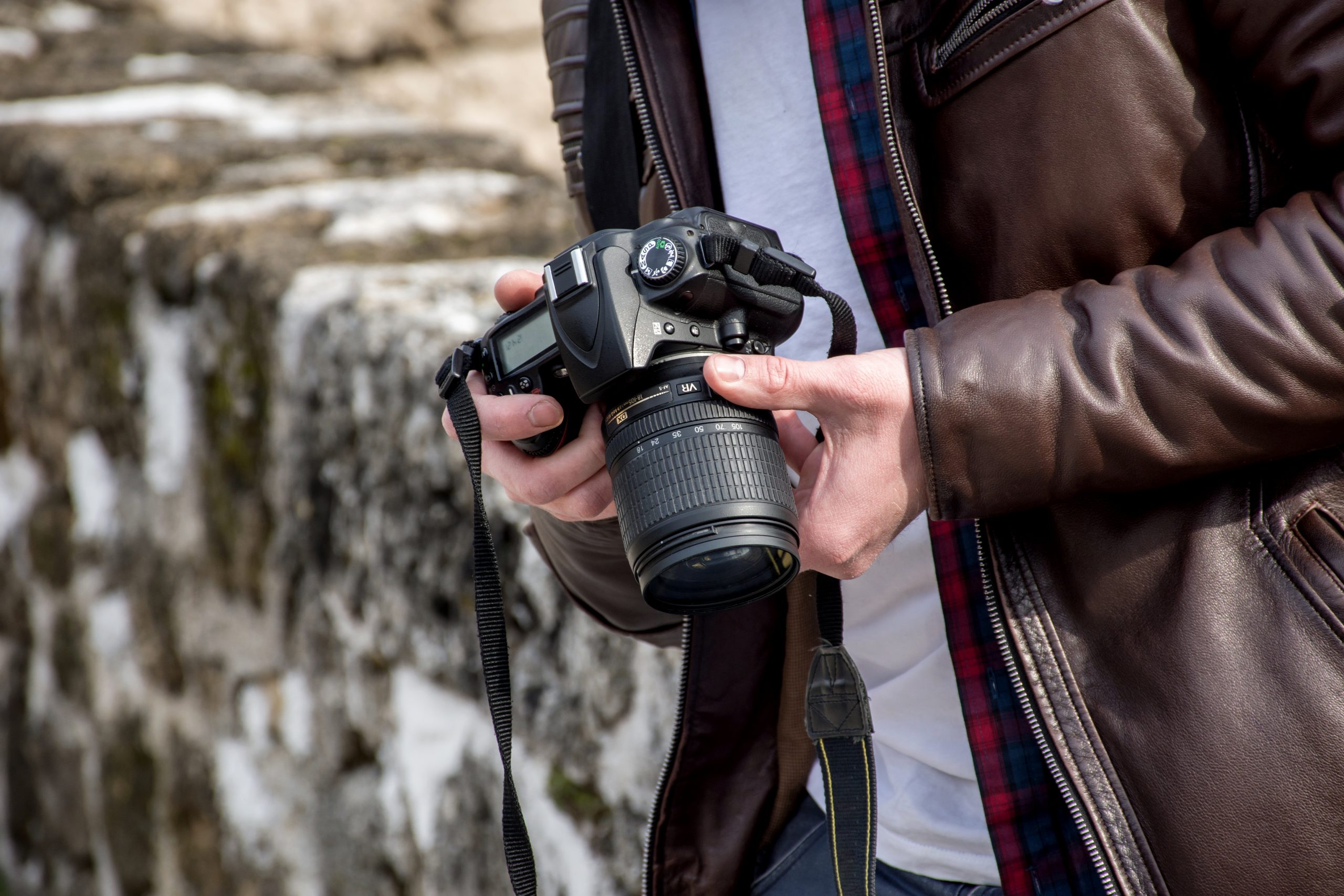 Ung man med kamera och paketobjektiv