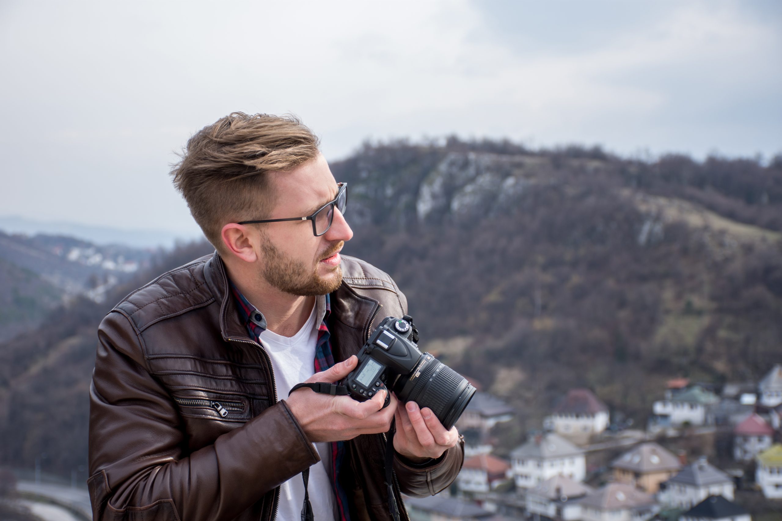 Ung mann med kamera og settobjektiv