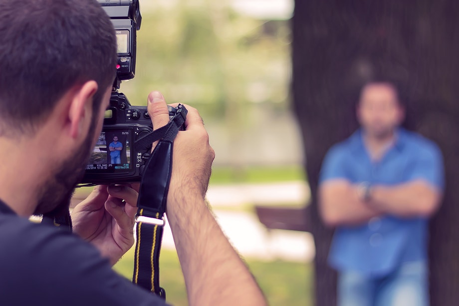 Mies ottaa kuvaa toisesta ulkona