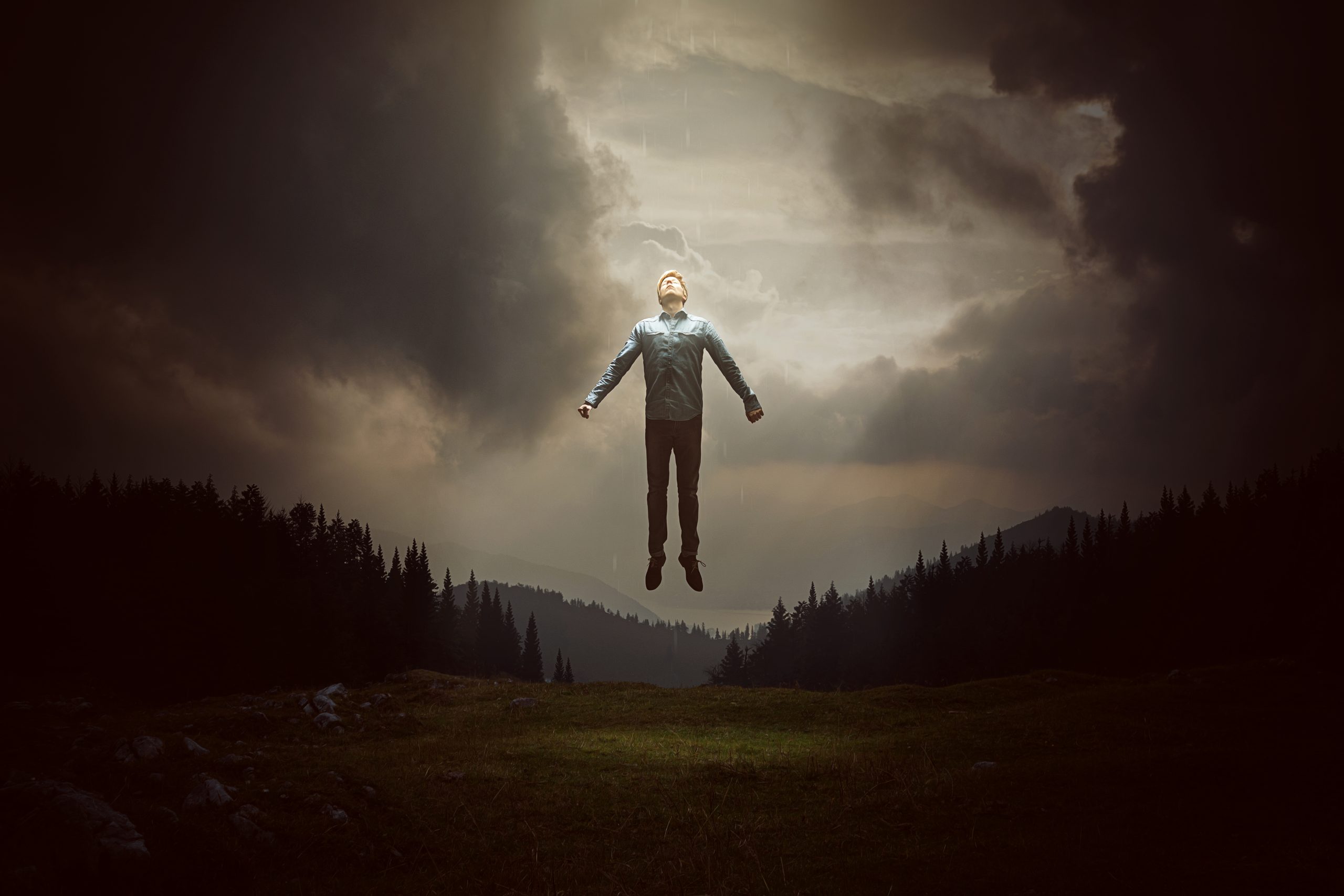 Mann som svever i luften over landskap