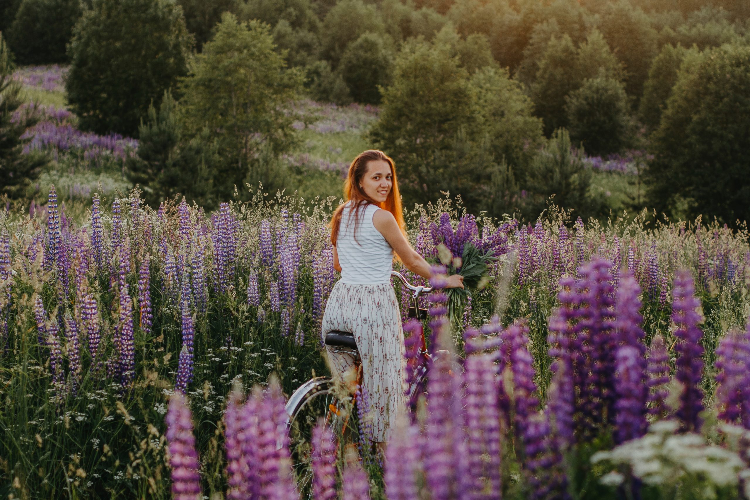 Ung pige med cykel på blomstermark