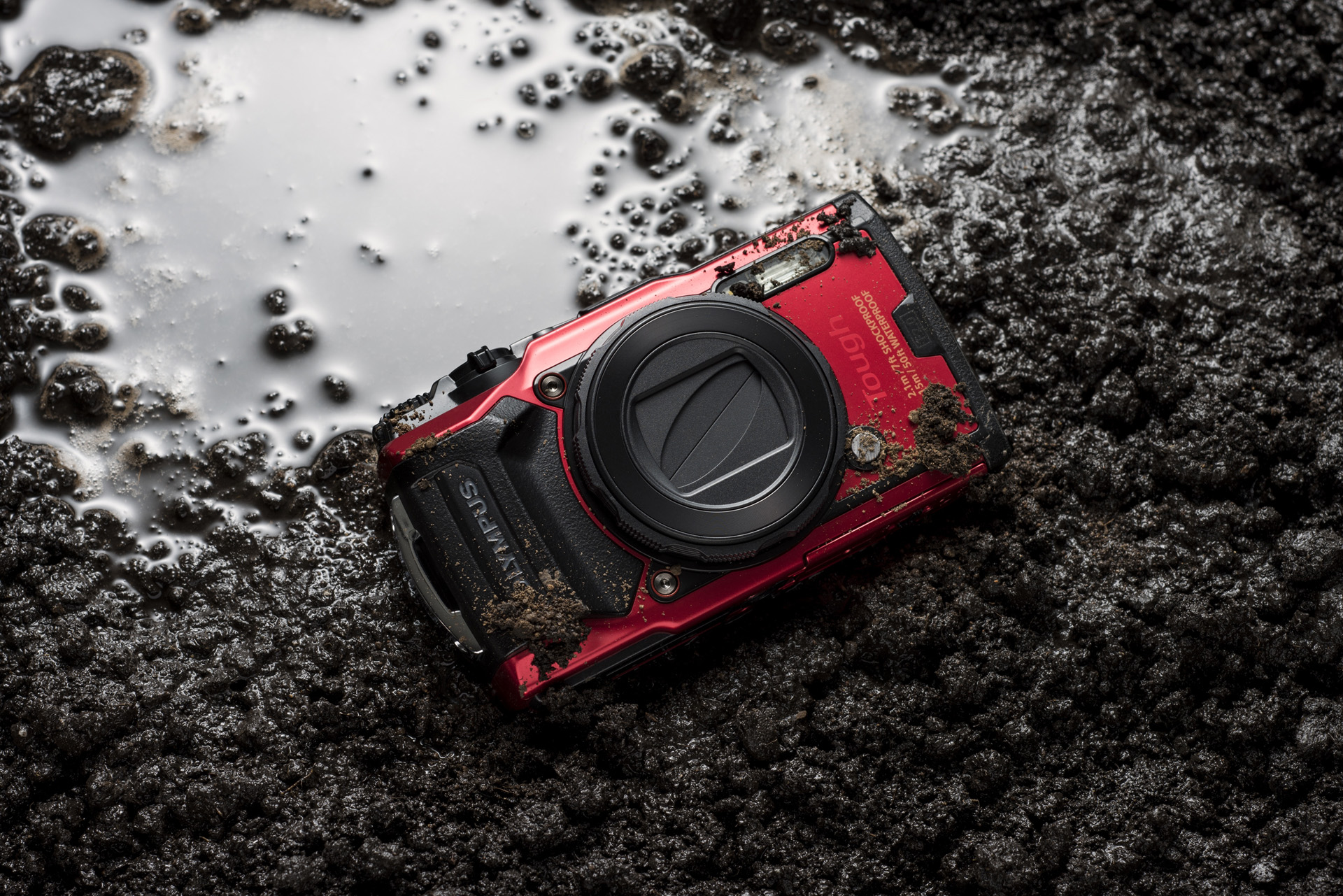 Rødt Olympus Tough TG-6 kamera i mudder