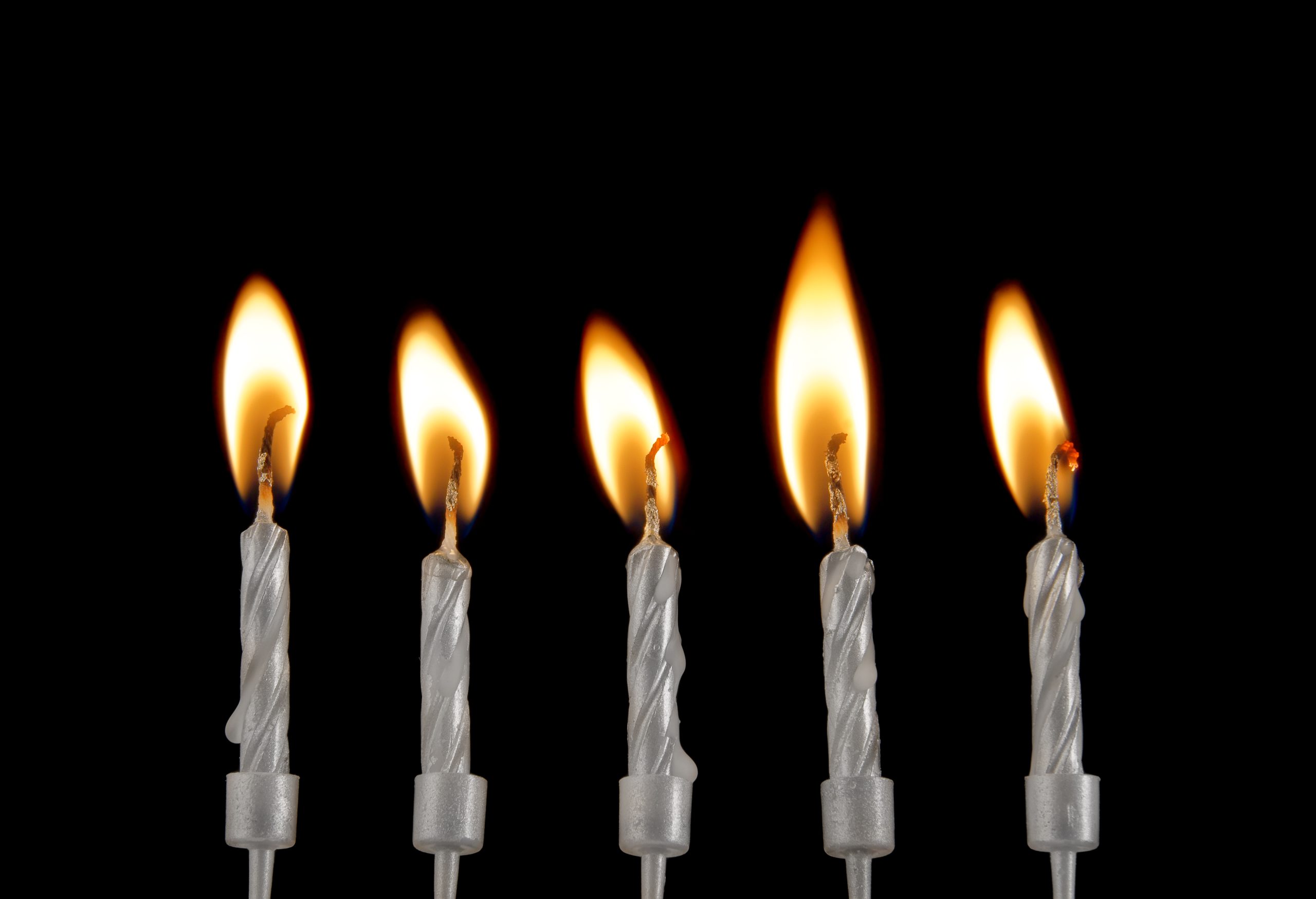 Silverfärgade stearinljus mot svart bakgrund