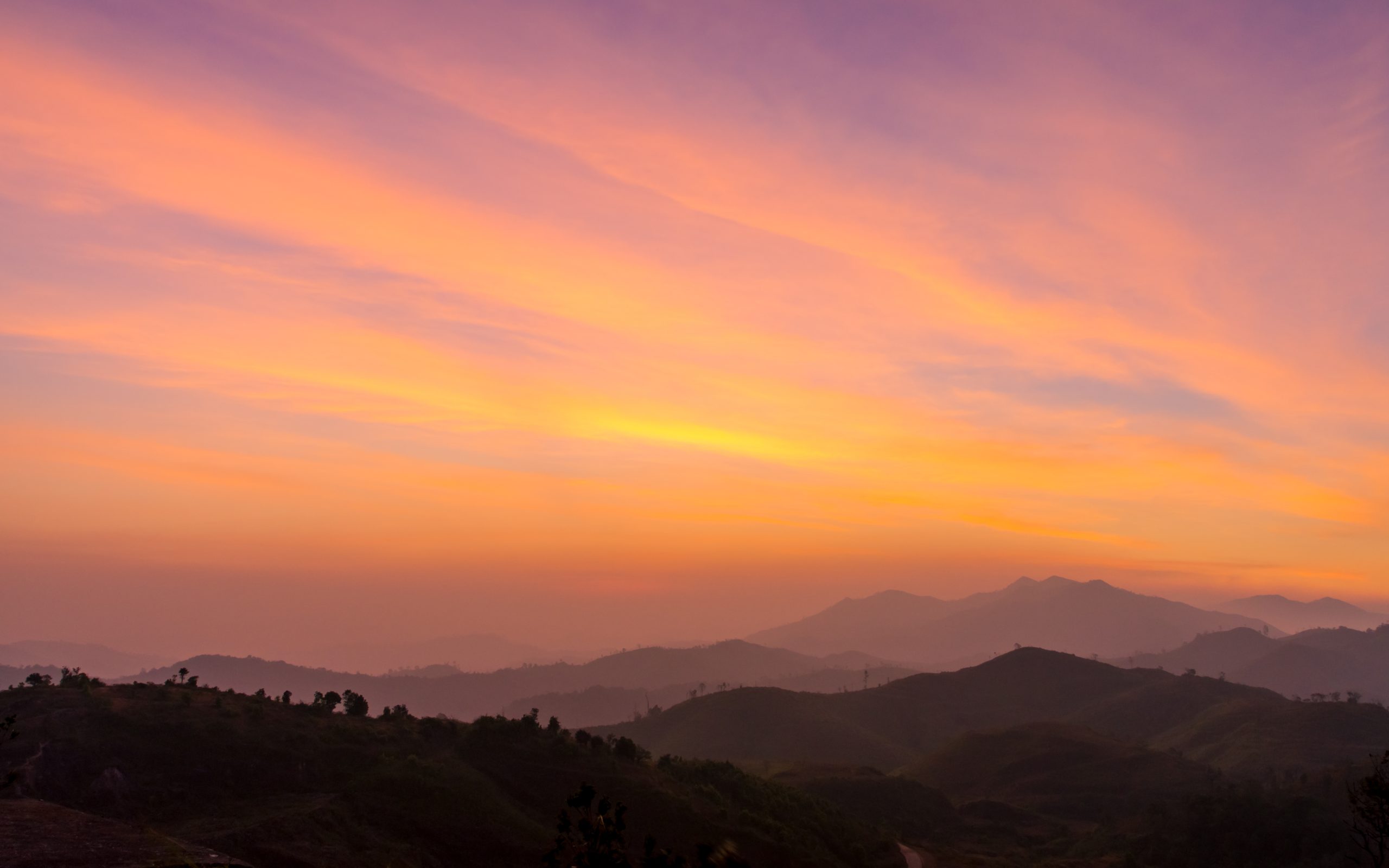Solnedgang over landskab med flere lag
