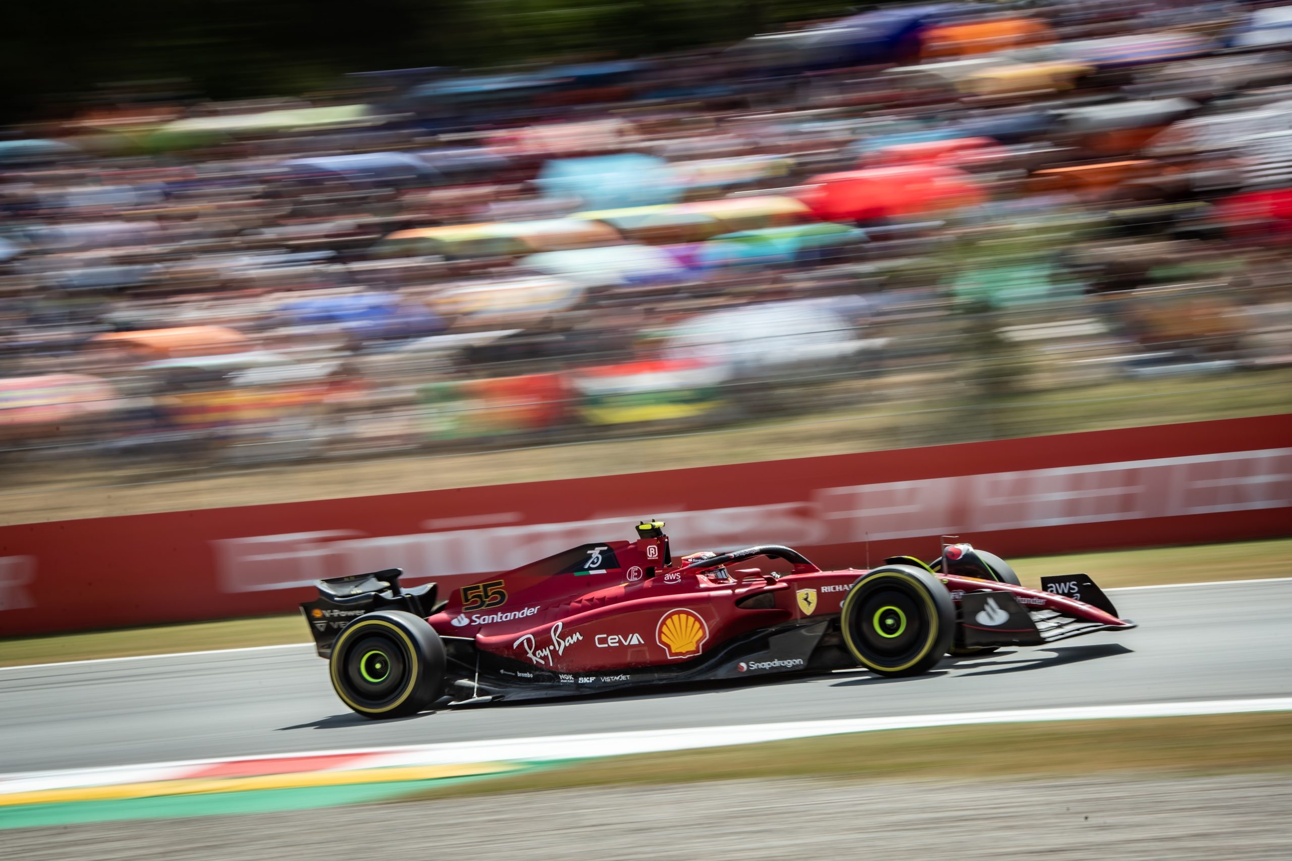 rød formel 1 racerbil fra Ferrari kører hurtigt henad bane hvor den er affotograferet