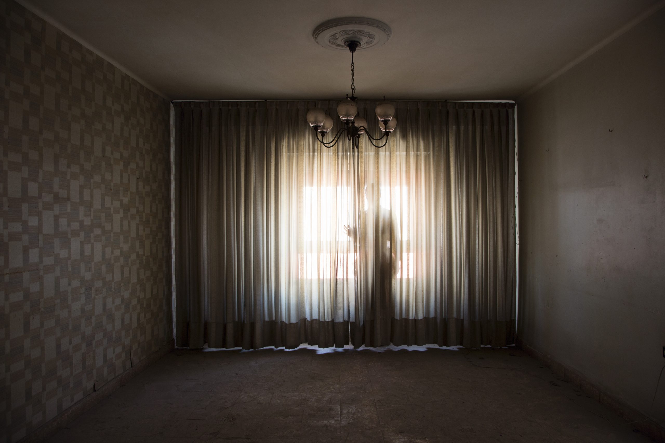 skikkelse bag et gardin i modlys