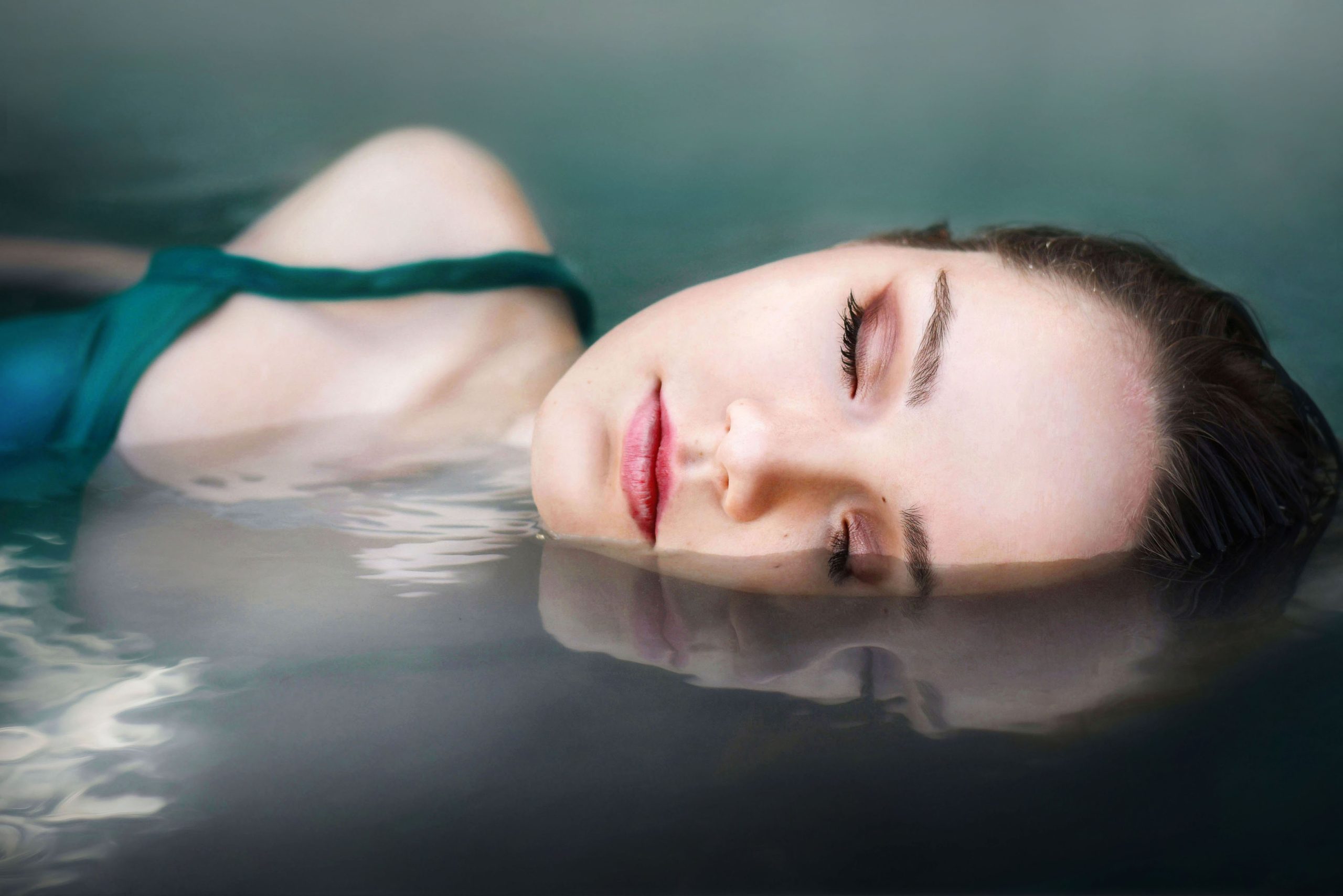 Kvindes ansigt spejles i vandet i en sø