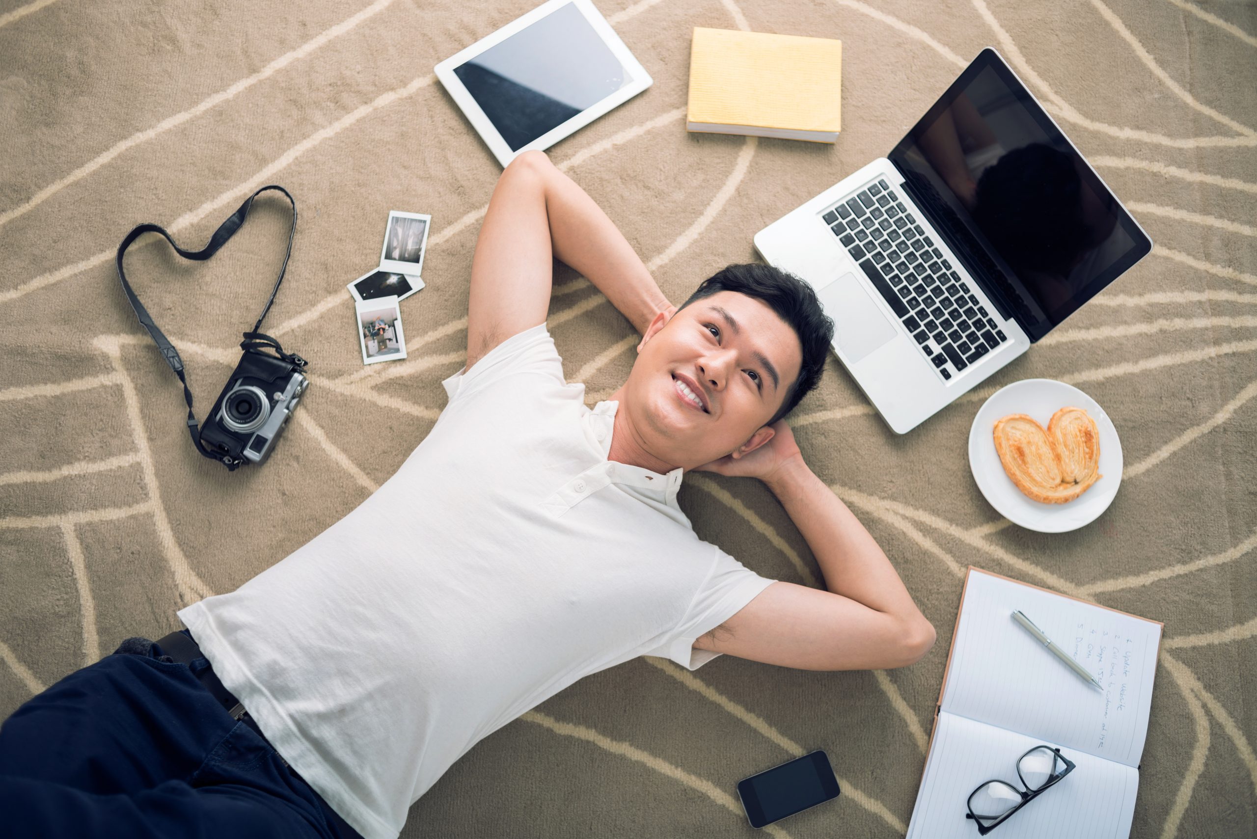 Mand ligger på gulvet og drømmer om ny fotoudstyr