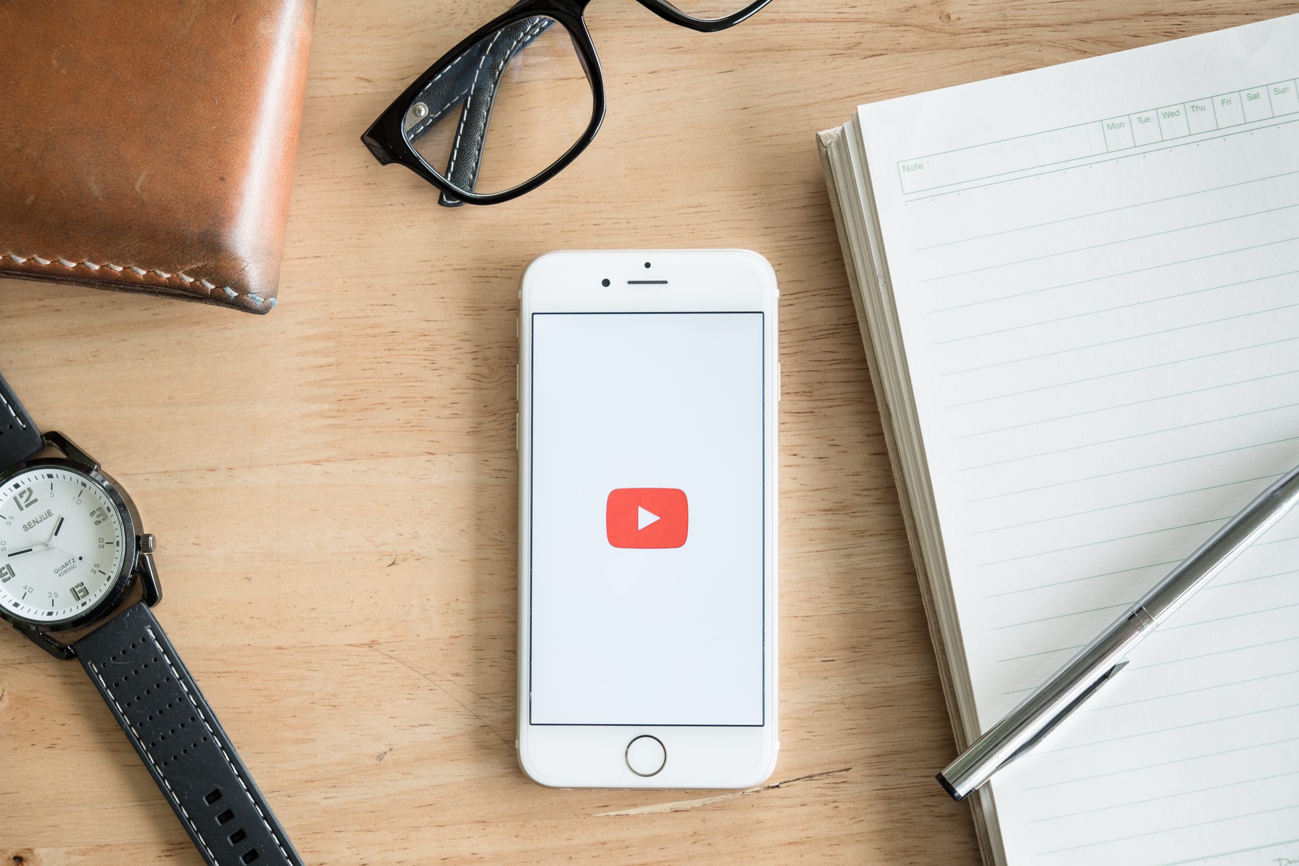 Smartphone på skrivebord med YouTube-logo