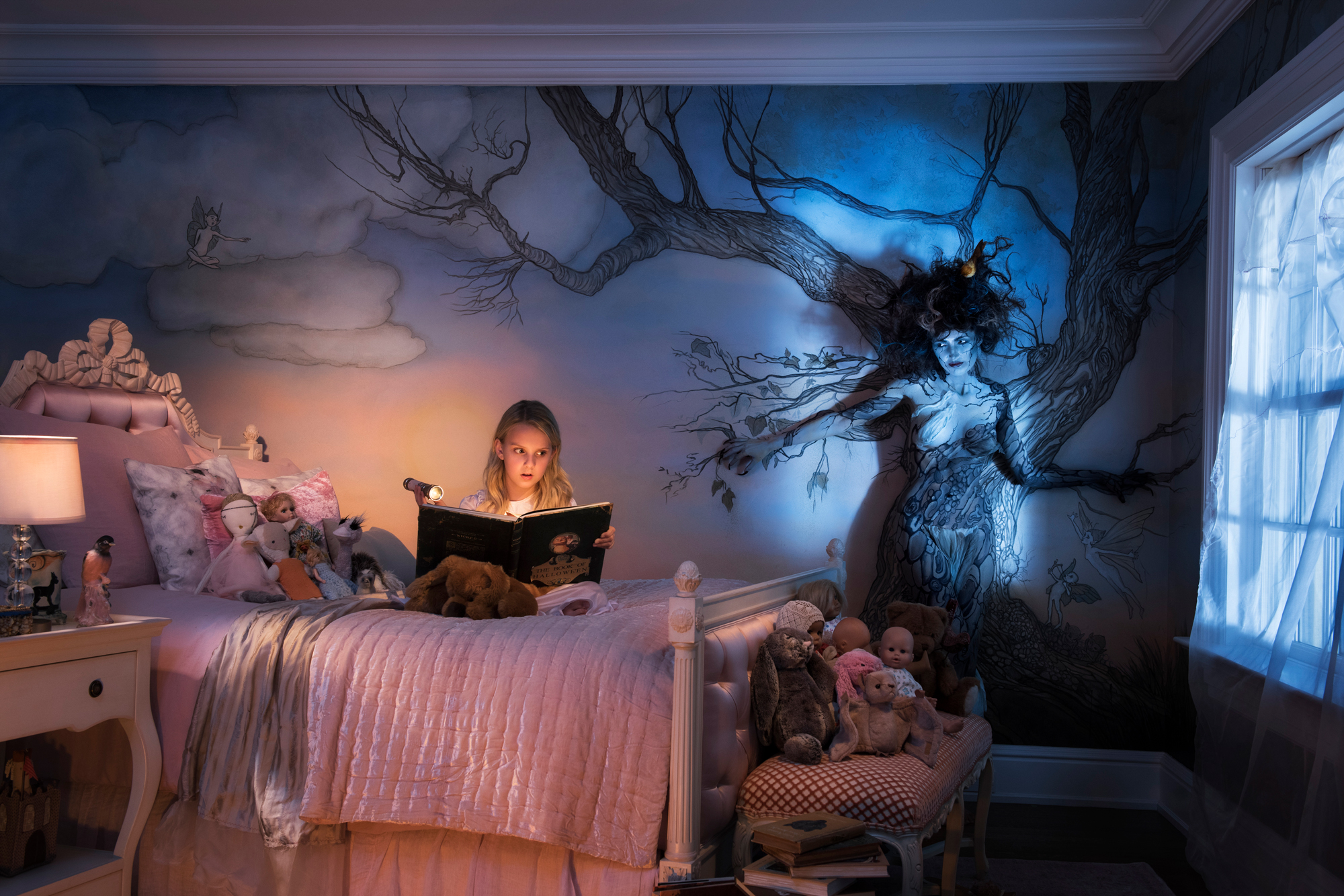 Lille pige læser gyserhistorier på sit værelse
