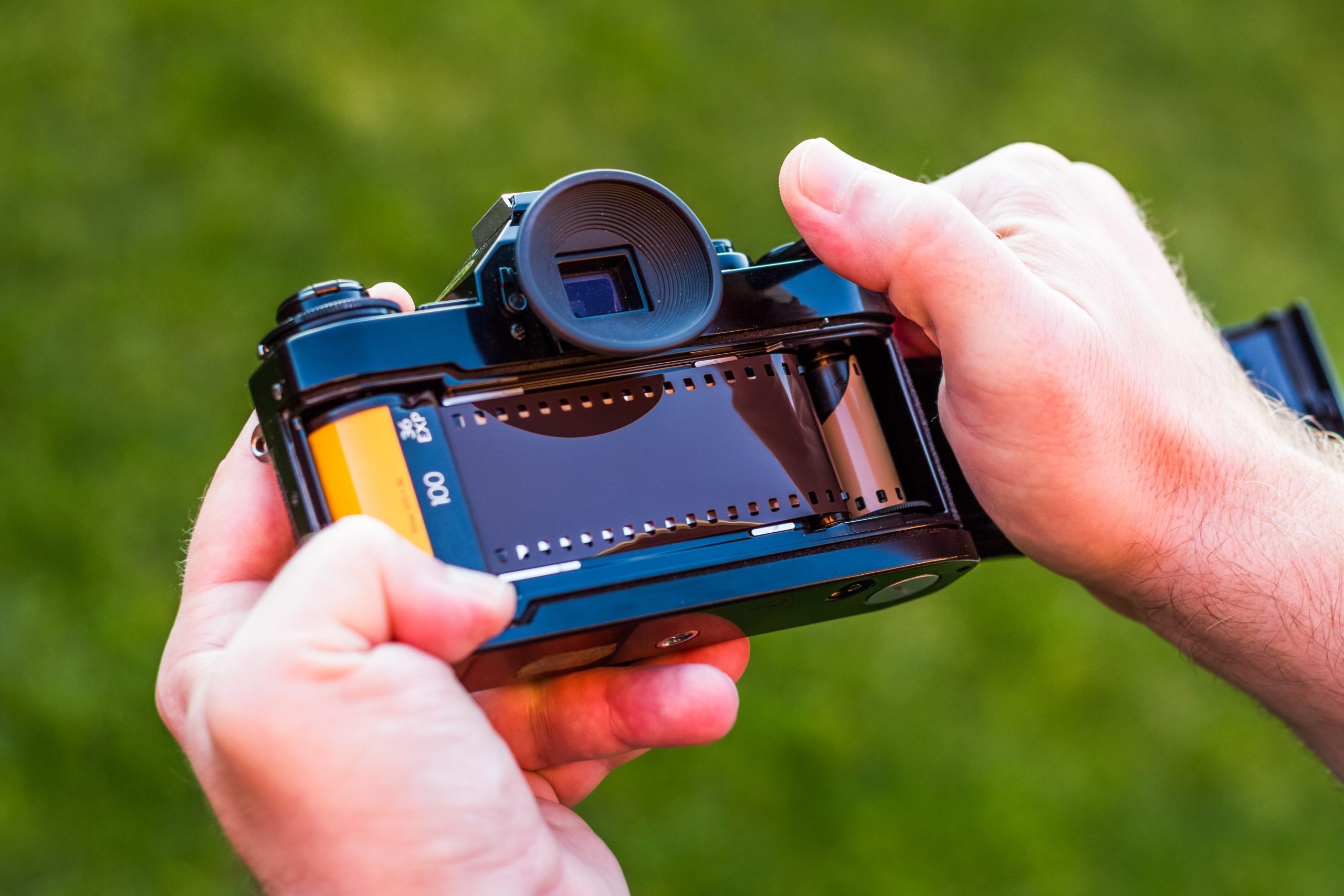 Käsissä on filmiä käyttävä kamera.